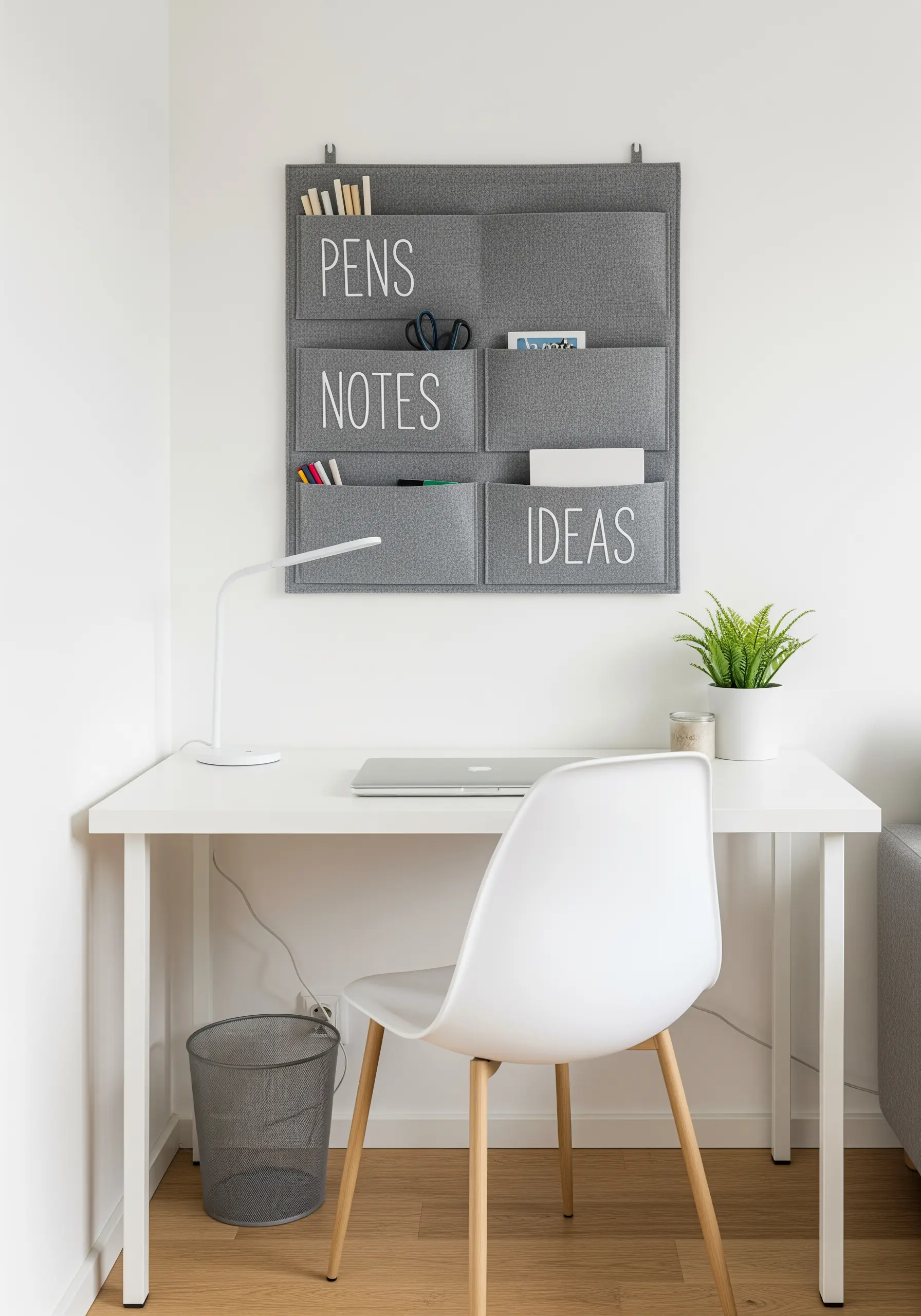 White embroidered lettering on a grey felt wall organizer for a home office.