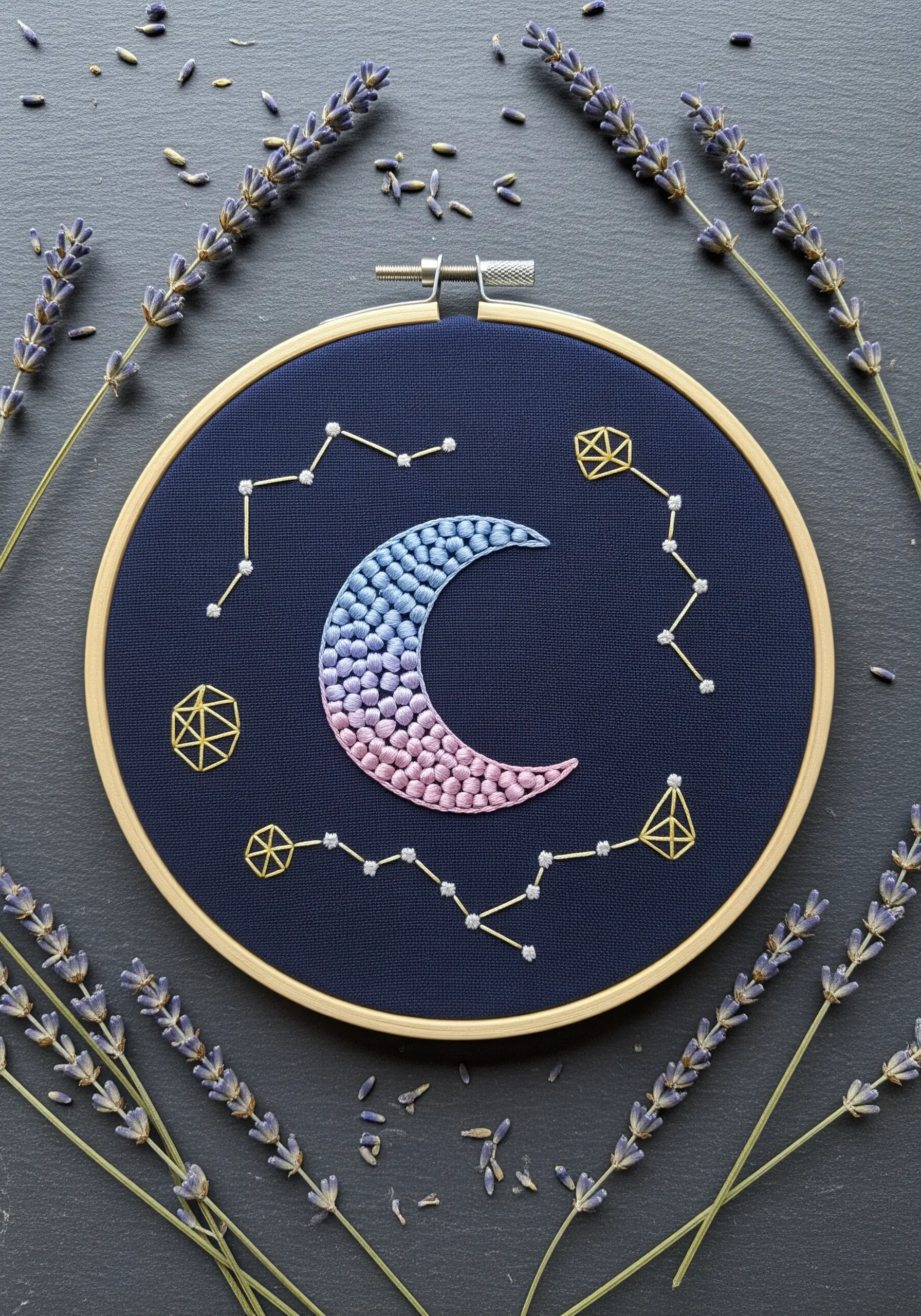 Crescent moon filled with pink and blue French knot gradients on dark fabric.