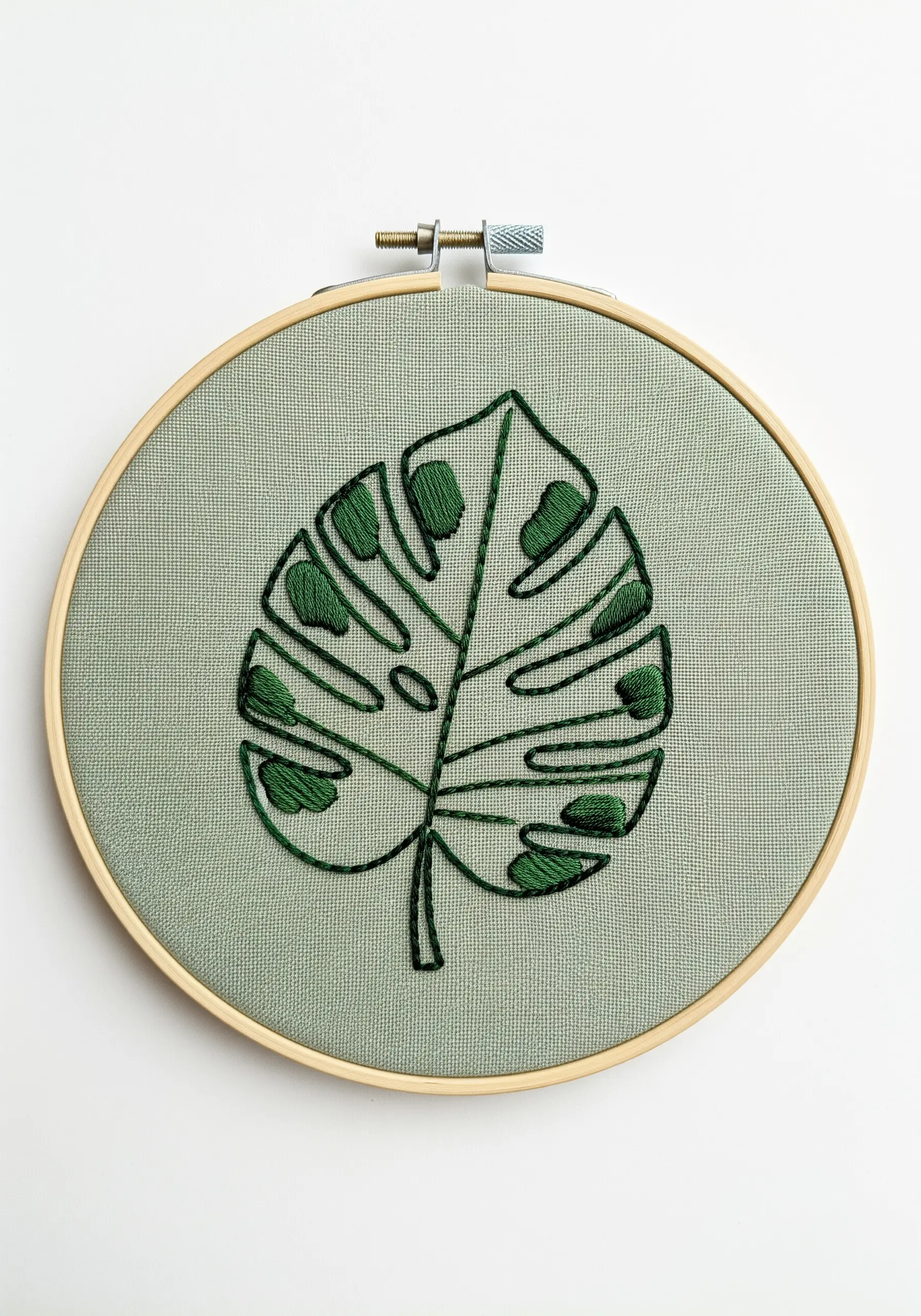 Monstera leaf embroidery using outline and selective satin stitch fills.