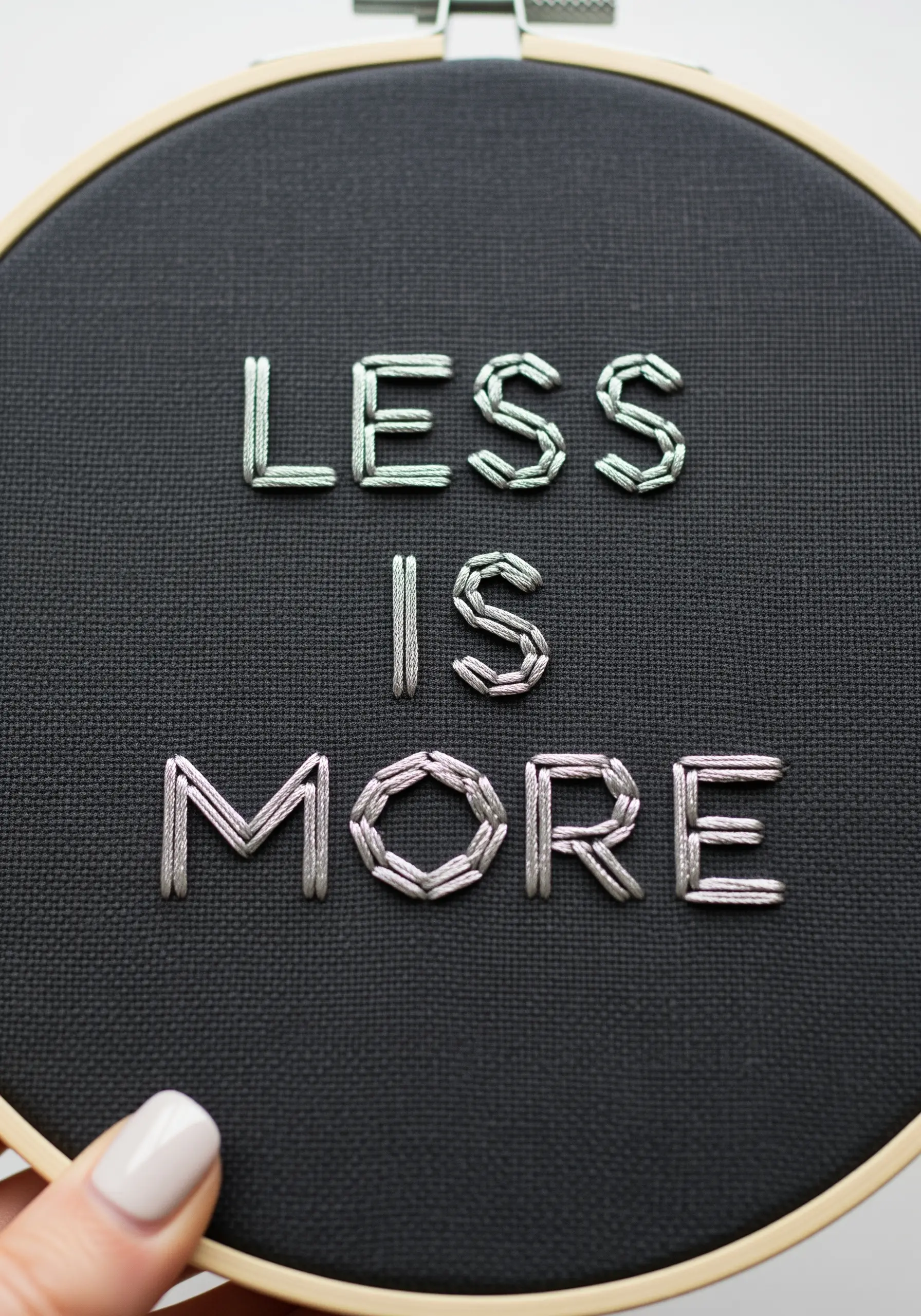 Minimalist lettering using parallel satin stitches with metallic thread