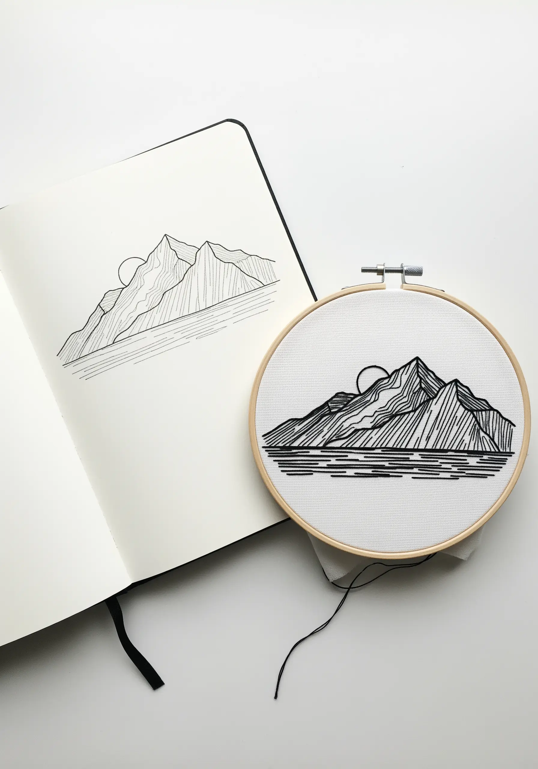 Black thread embroidery of a mountain range, mimicking a pen sketch.