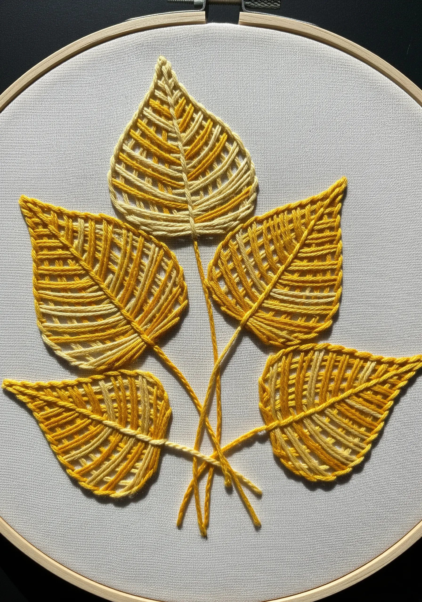 Five skeleton leaves embroidered with yellow woven stitches and outlined frames.