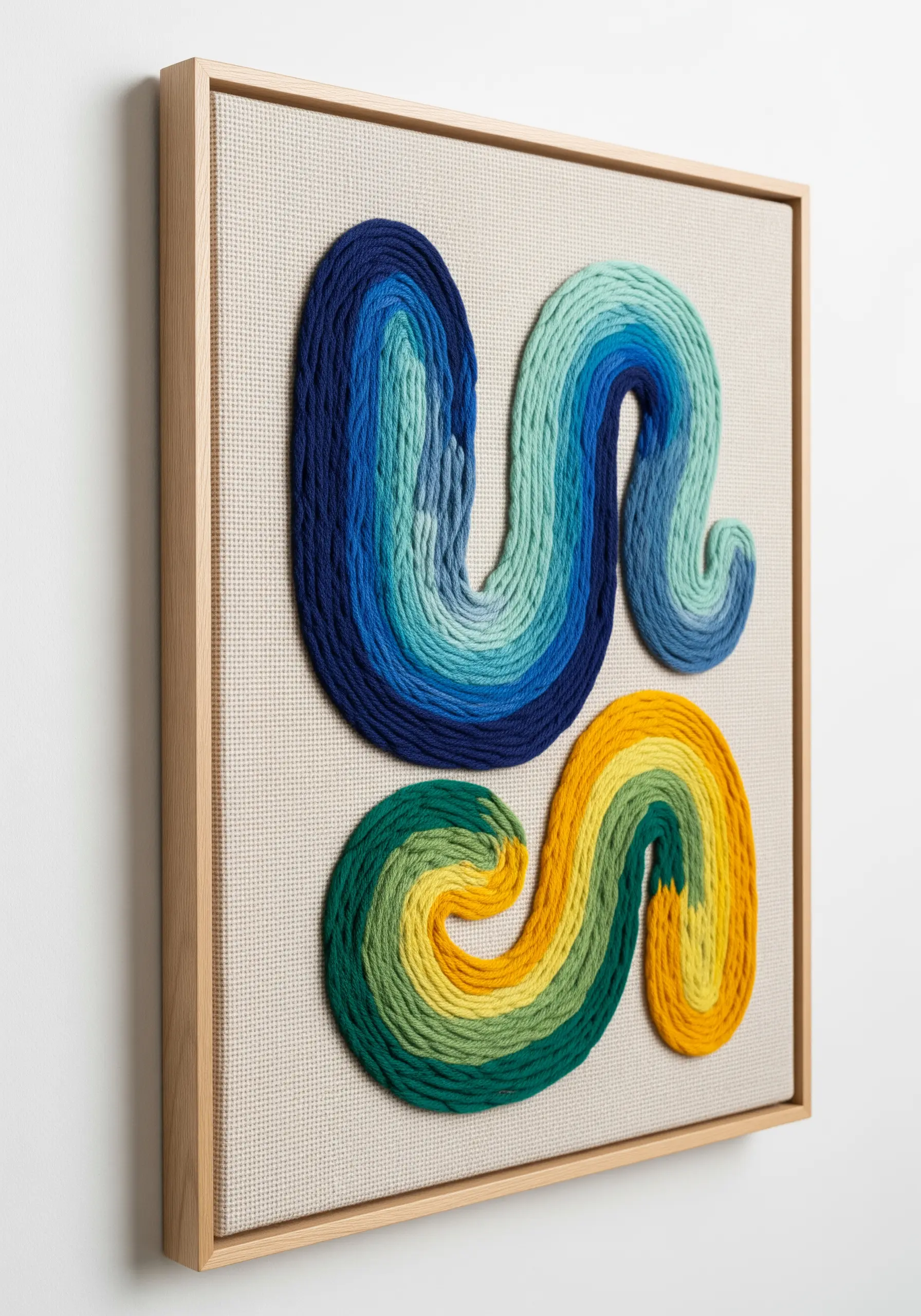 Framed 3D embroidery with thick, color-blended cords in blue, green, and yellow.