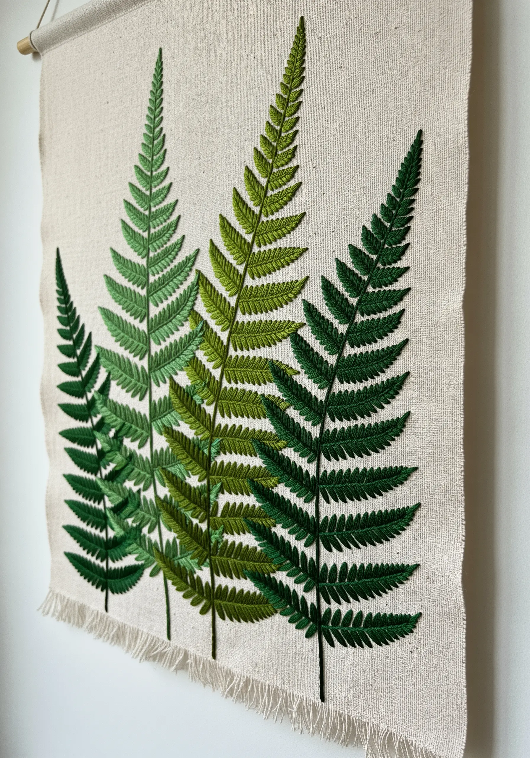 Four embroidered ferns in varying shades of green, creating a sense of depth.