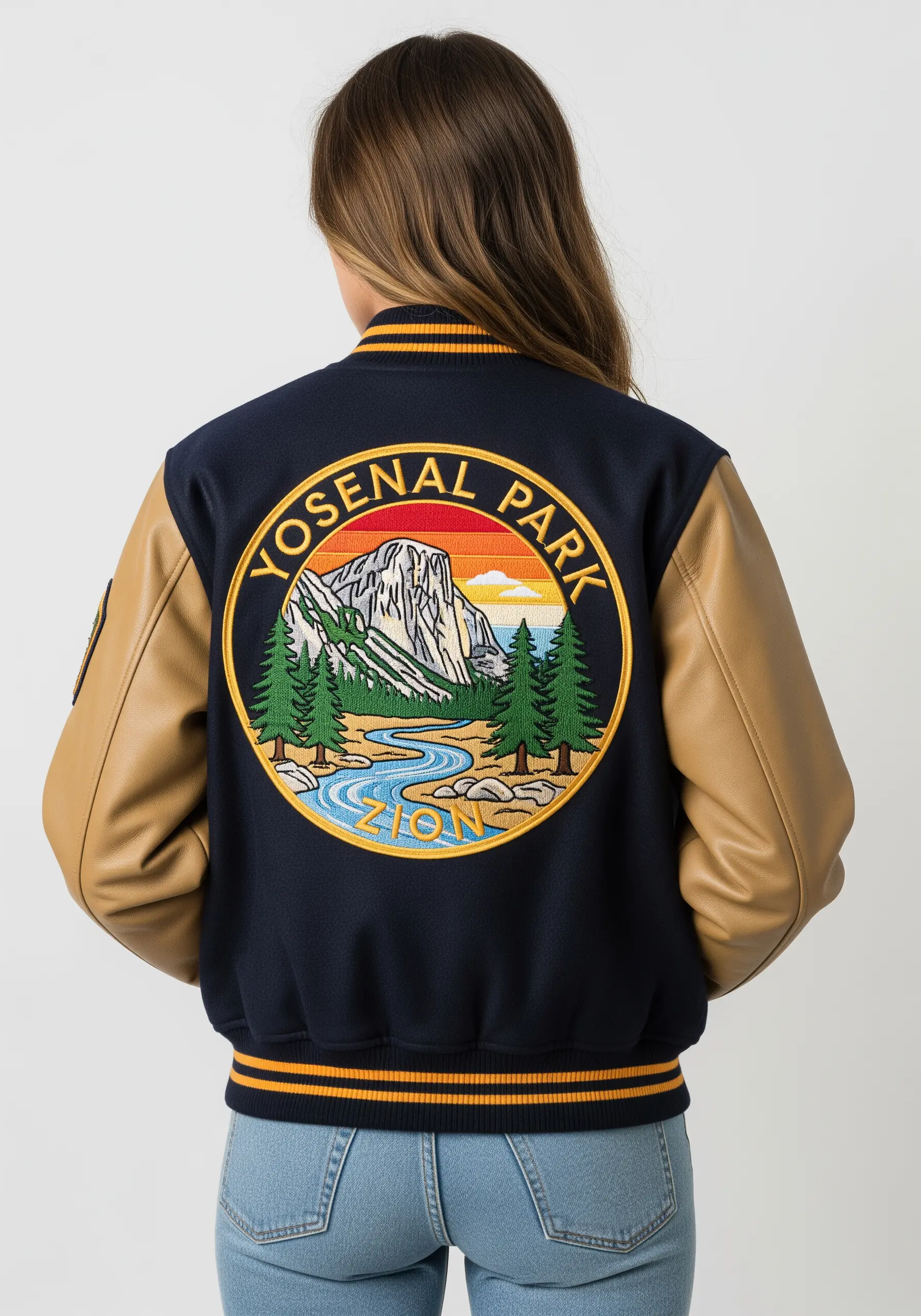 A circular embroidered patch of a national park scene on a varsity jacket.