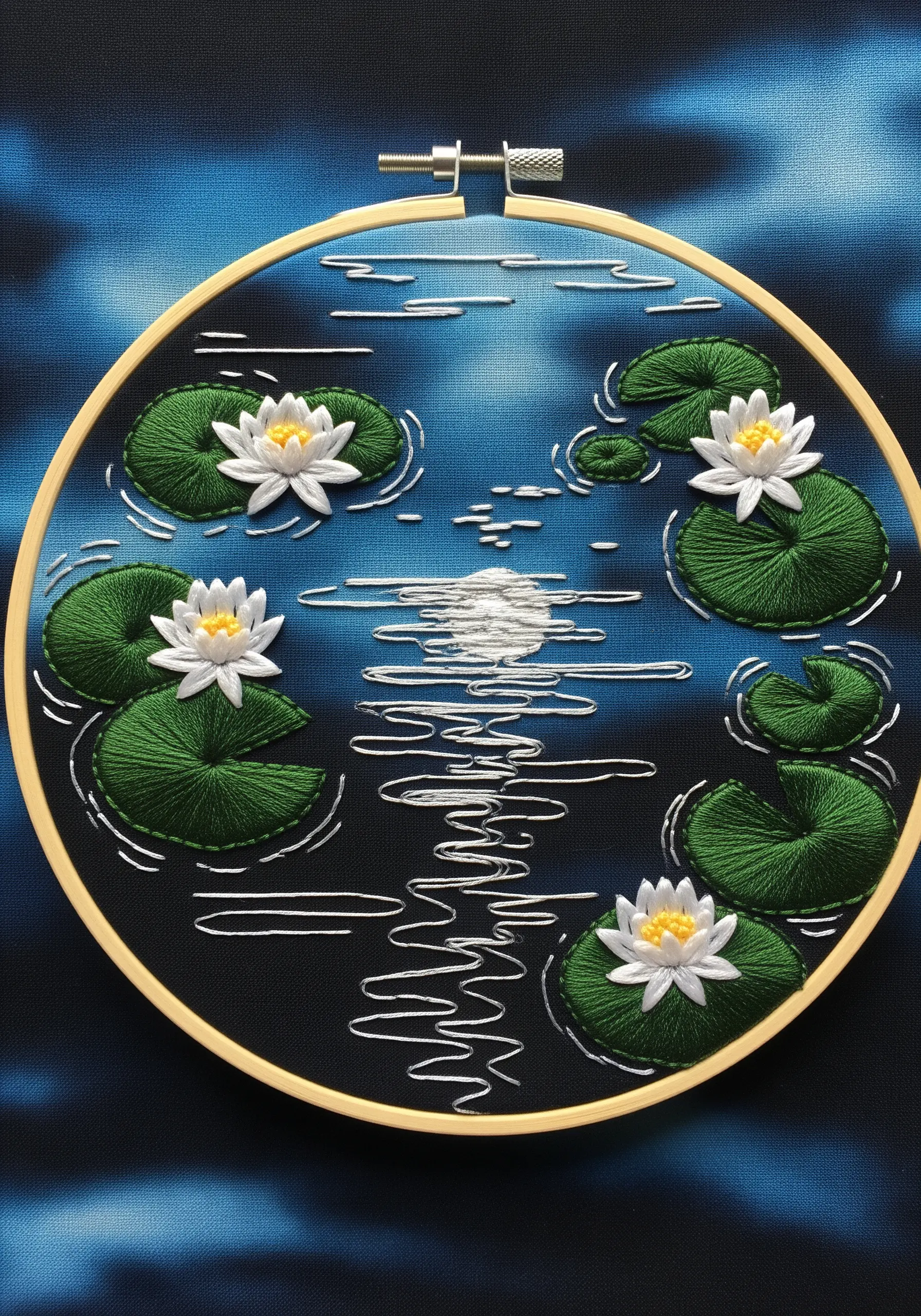 Embroidered water lilies on a dark blue pond with white stitches indicating moonlight reflections.