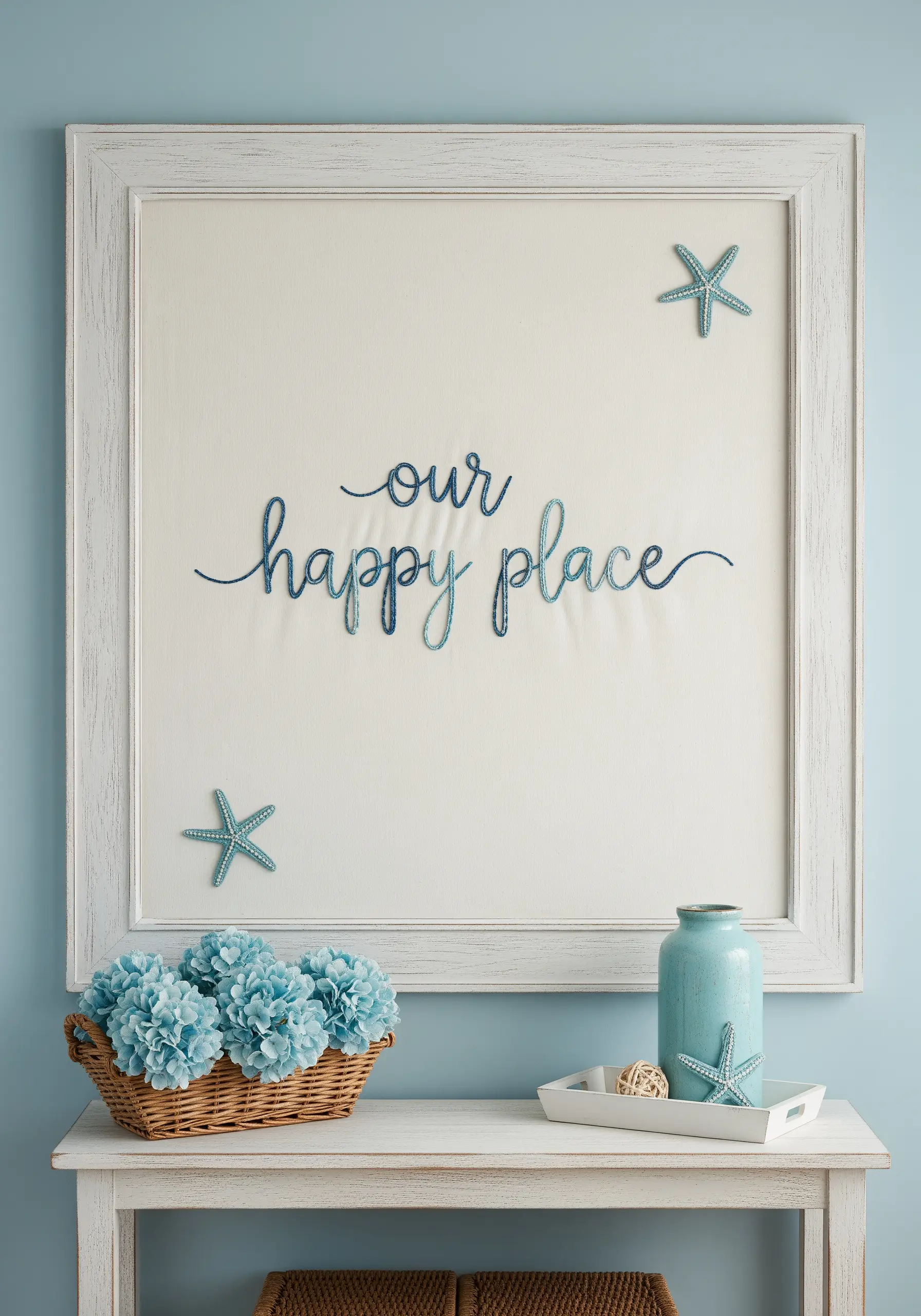 Embroidered 'our happy place' with blue ombre thread on a large framed canvas.
