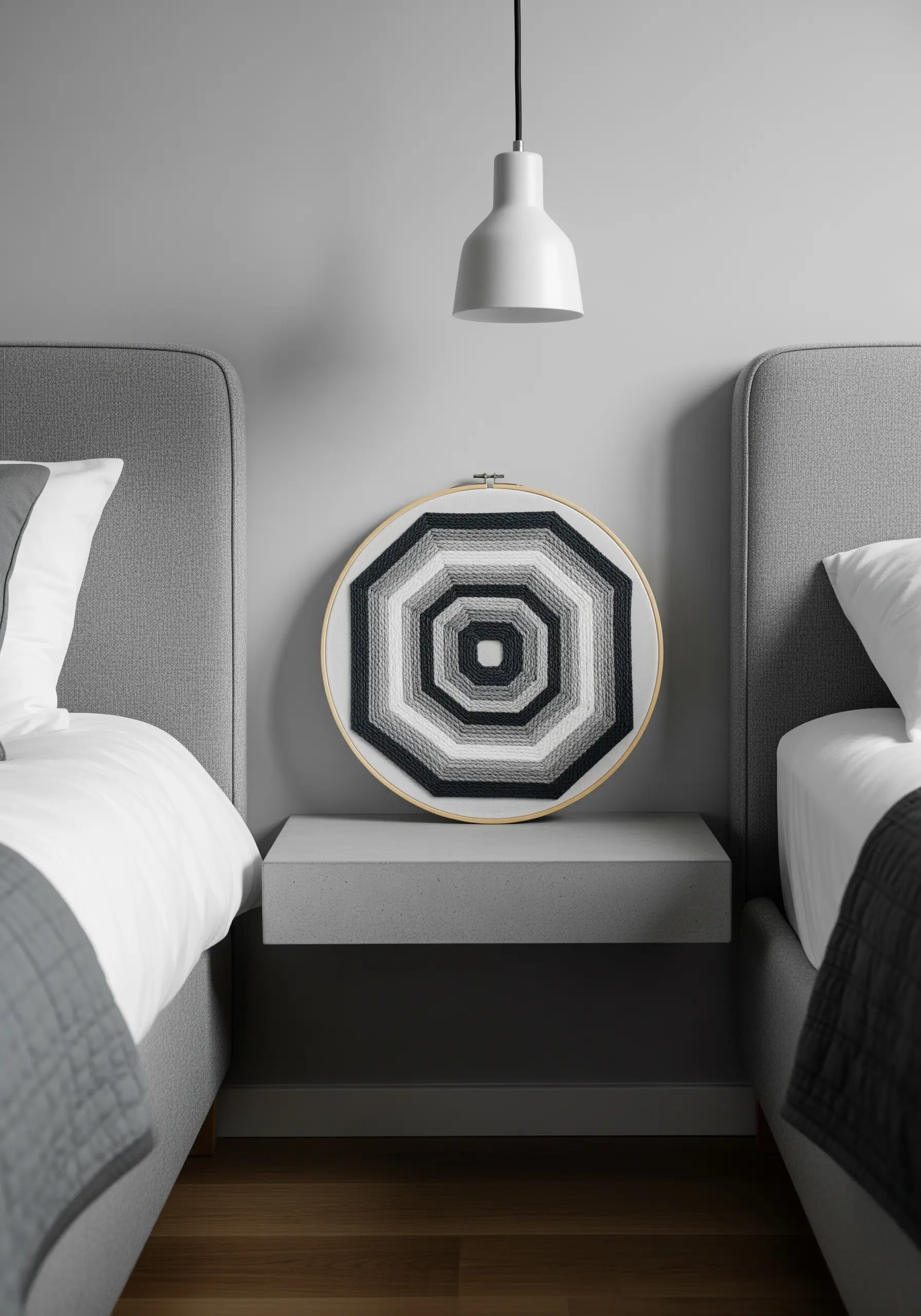 A geometric octagon pattern in a grayscale gradient, created by wrapping thread across the hoop.