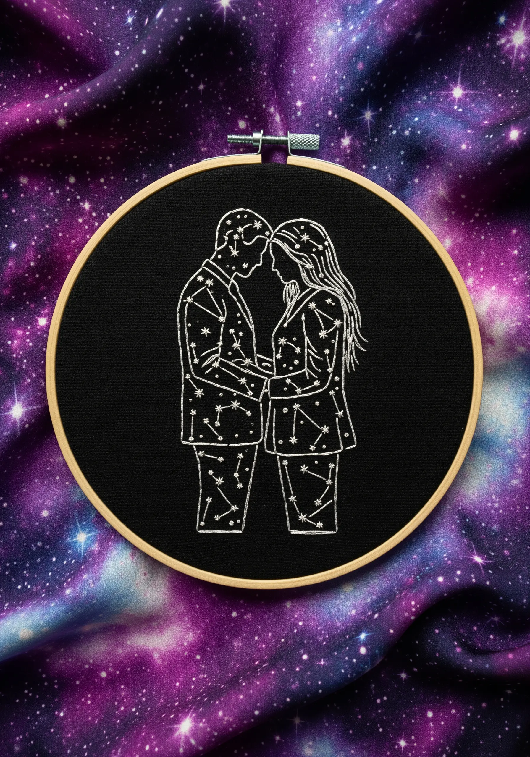 A couple's silhouette filled with embroidered constellations, stitched in white on black fabric.