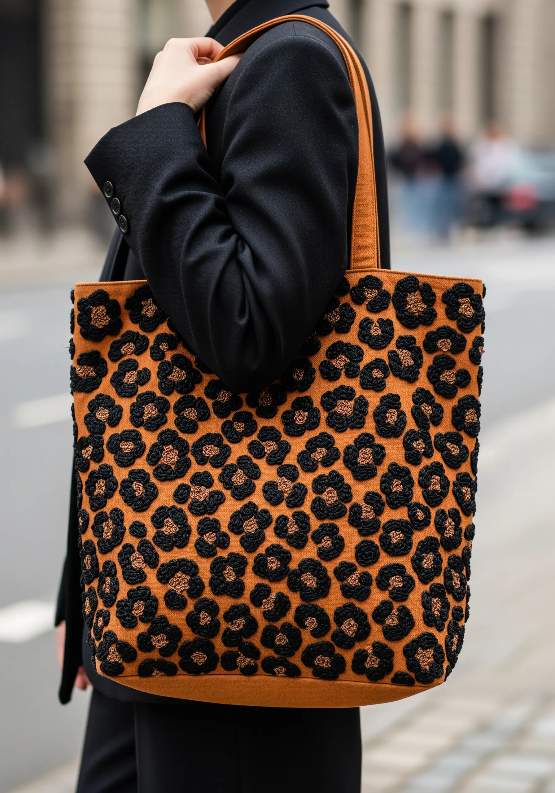 A textural leopard print pattern embroidered with French knots on a tan tote bag