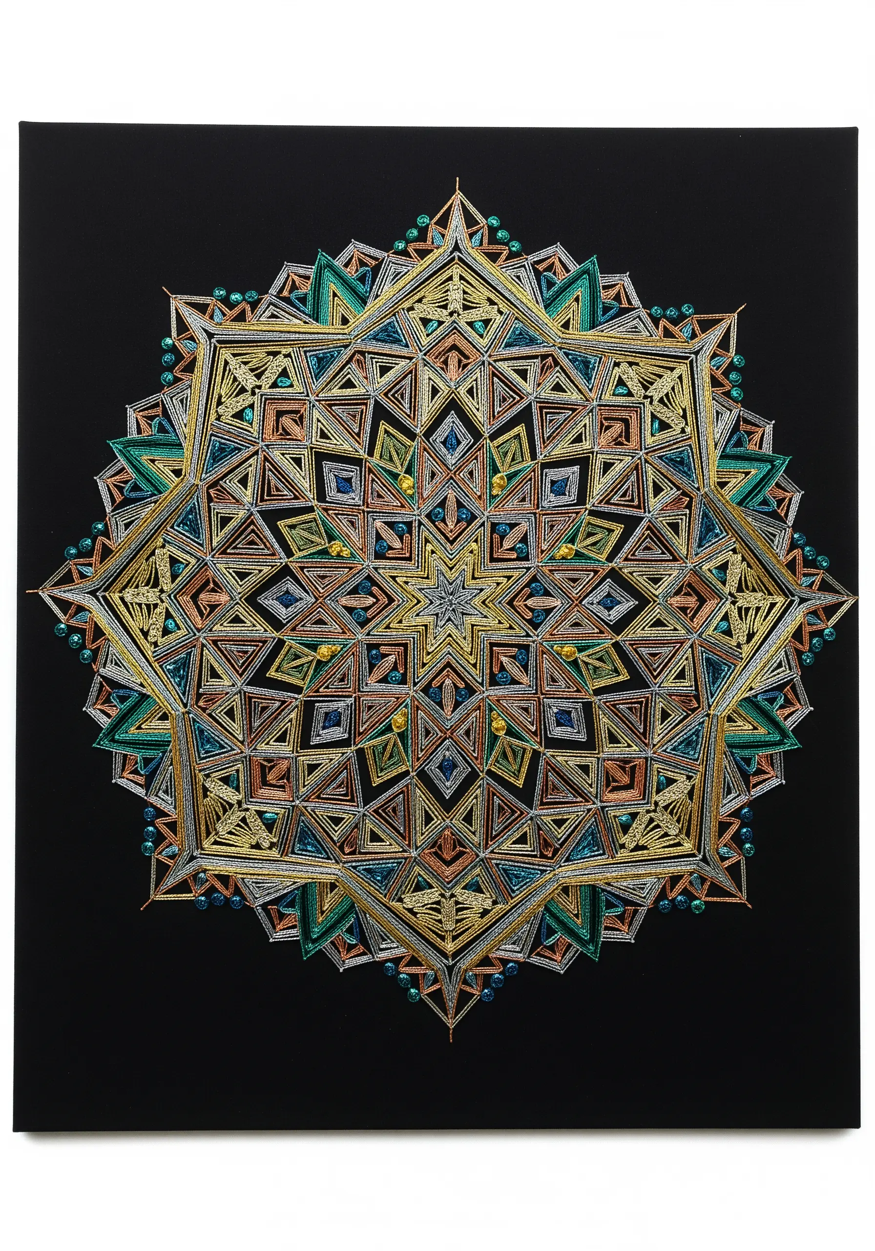 A highly intricate, geometric mandala woven with various colors of metallic thread on black canvas.