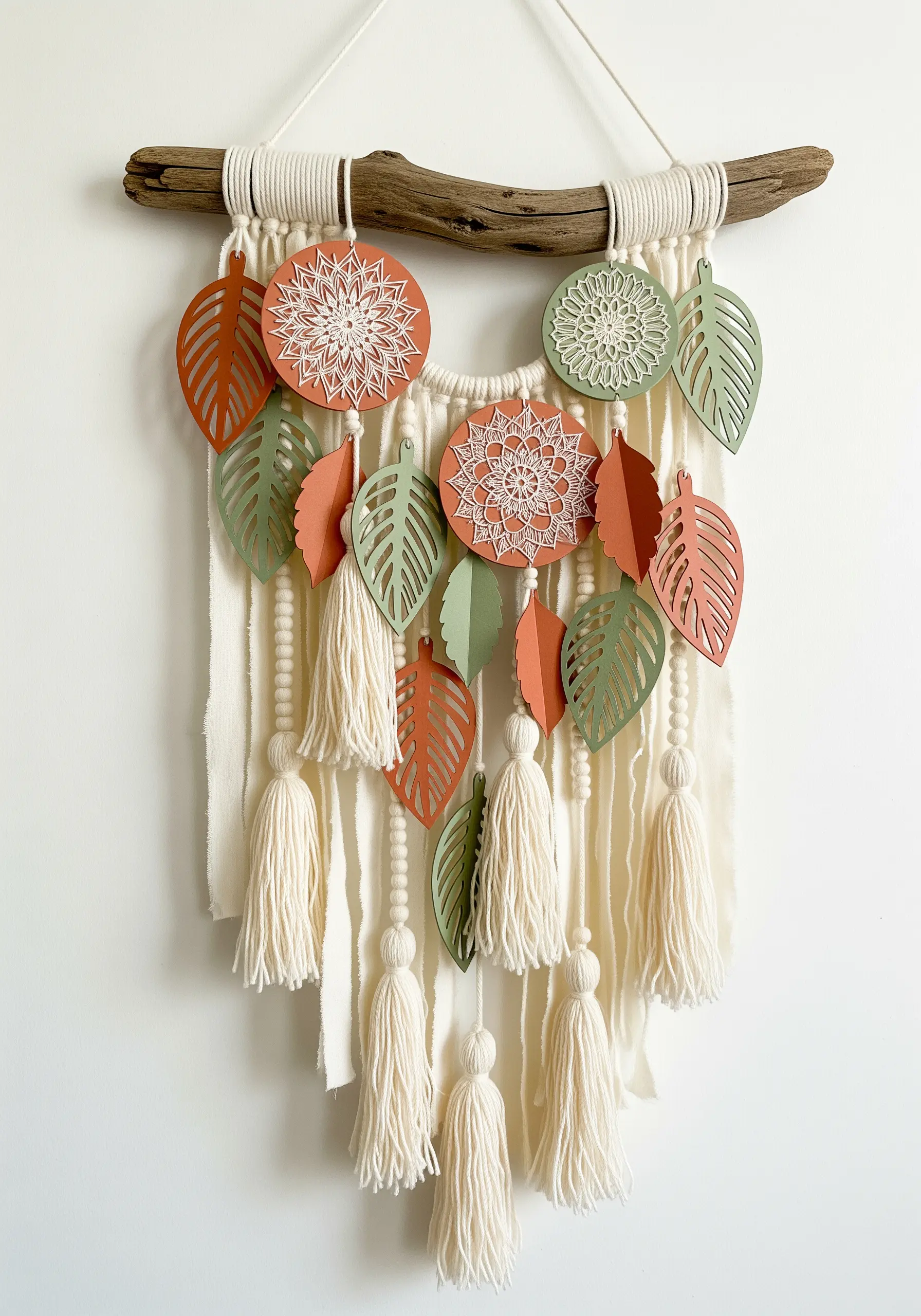 Macrame wall hanging with stitched paper mandalas, cut-out paper leaves, and yarn tassels.
