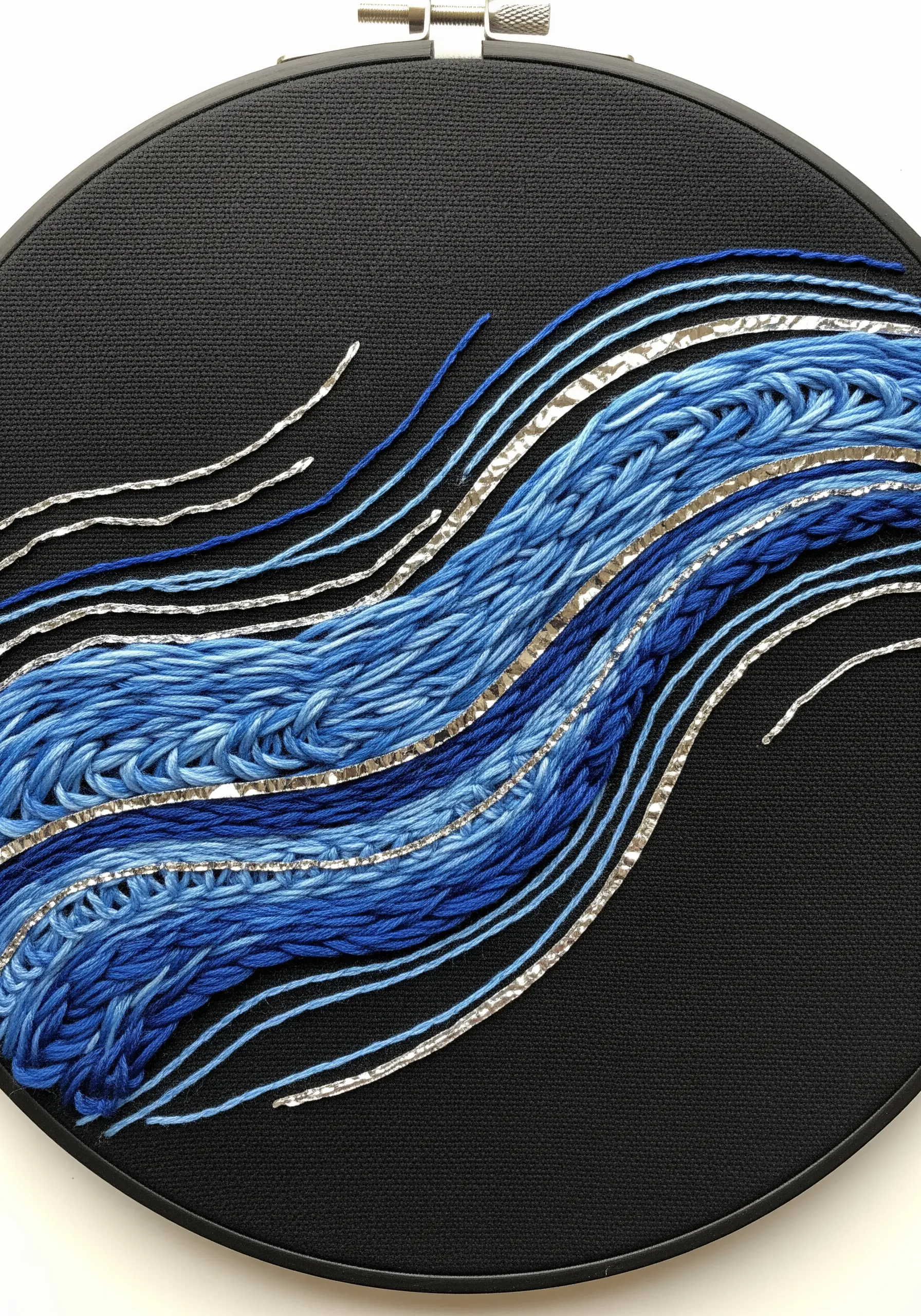 Abstract water embroidery using braided floss, satin stitch, and metallic ribbon.