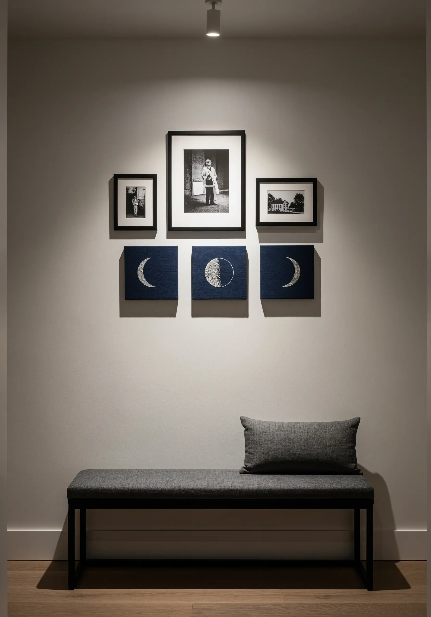 A gallery wall featuring three square canvases with embroidered moon phases in white on navy blue.