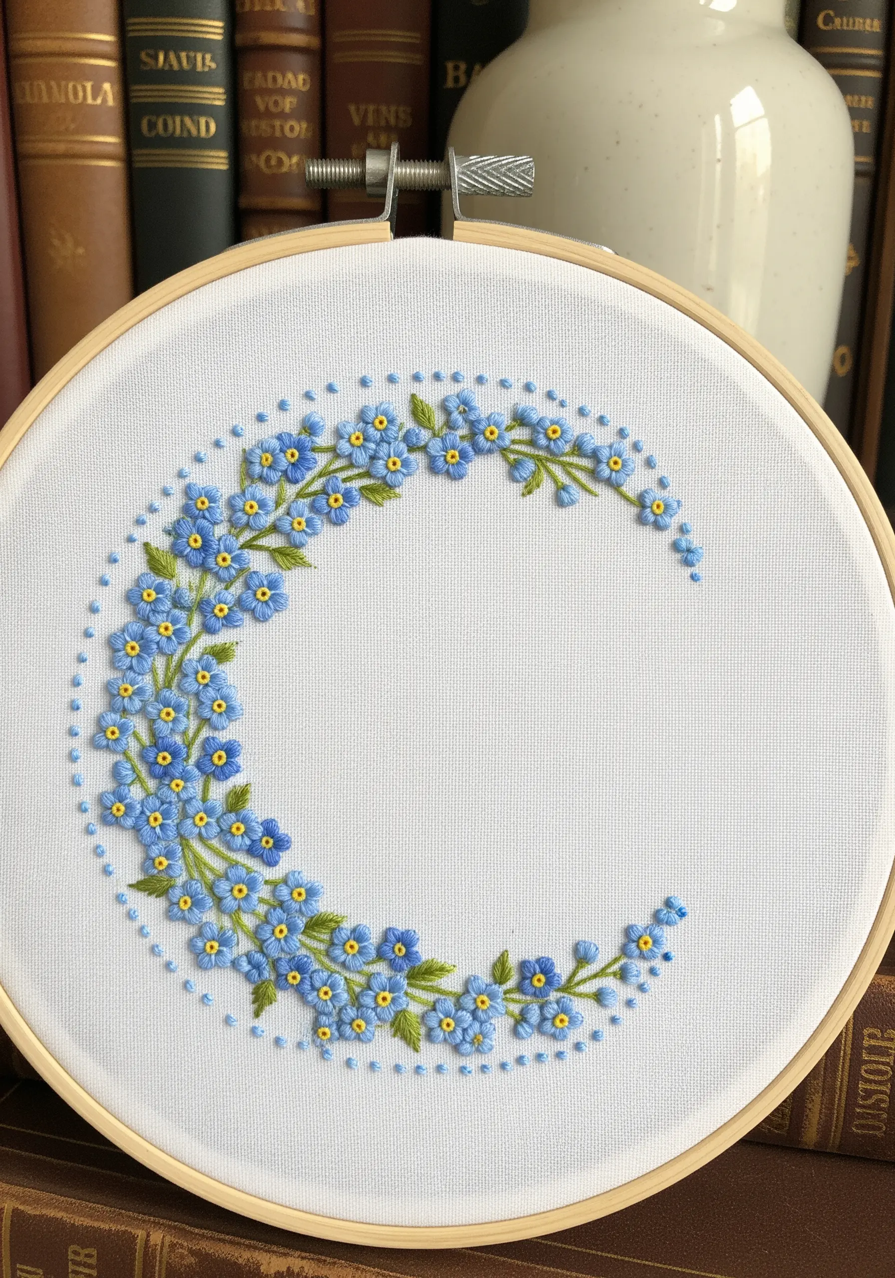 Crescent-shaped embroidery of blue forget-me-nots using lazy daisy stitches.