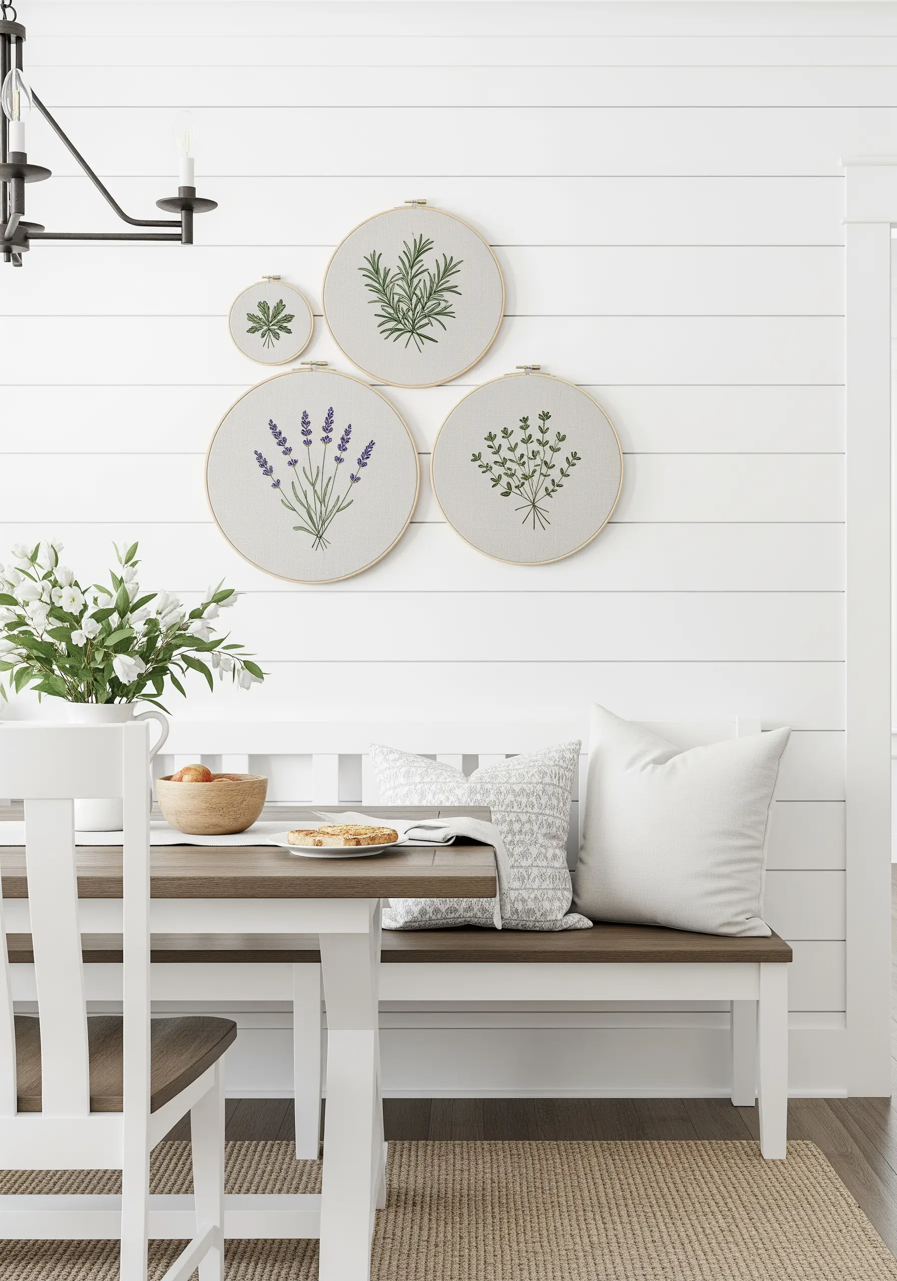 A gallery wall of four embroidery hoops featuring different culinary herbs.
