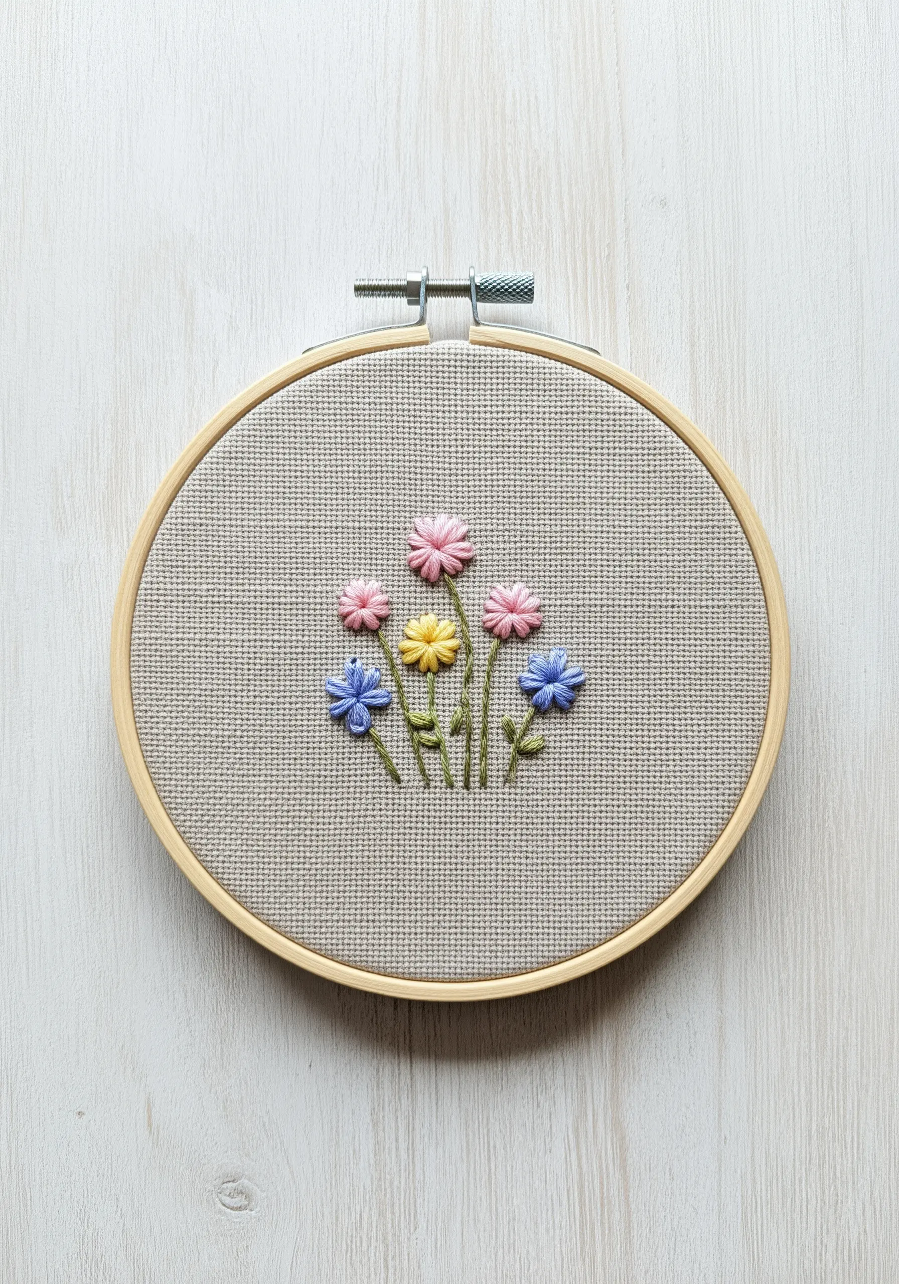 A small bunch of colorful wildflowers using lazy daisy and French knot stitches.