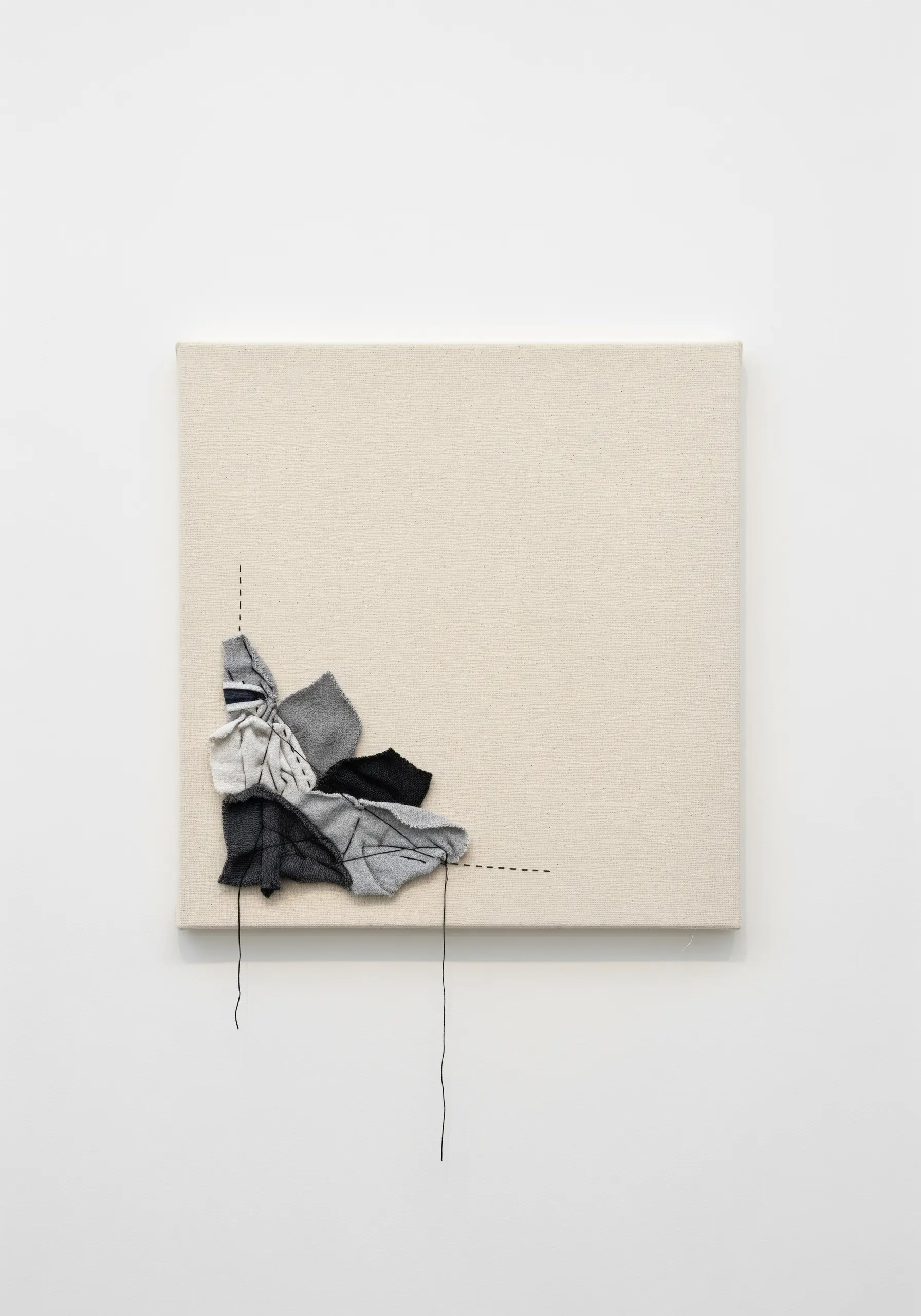 Minimalist art on a square canvas with a small cluster of fabric scraps stitched in one corner.