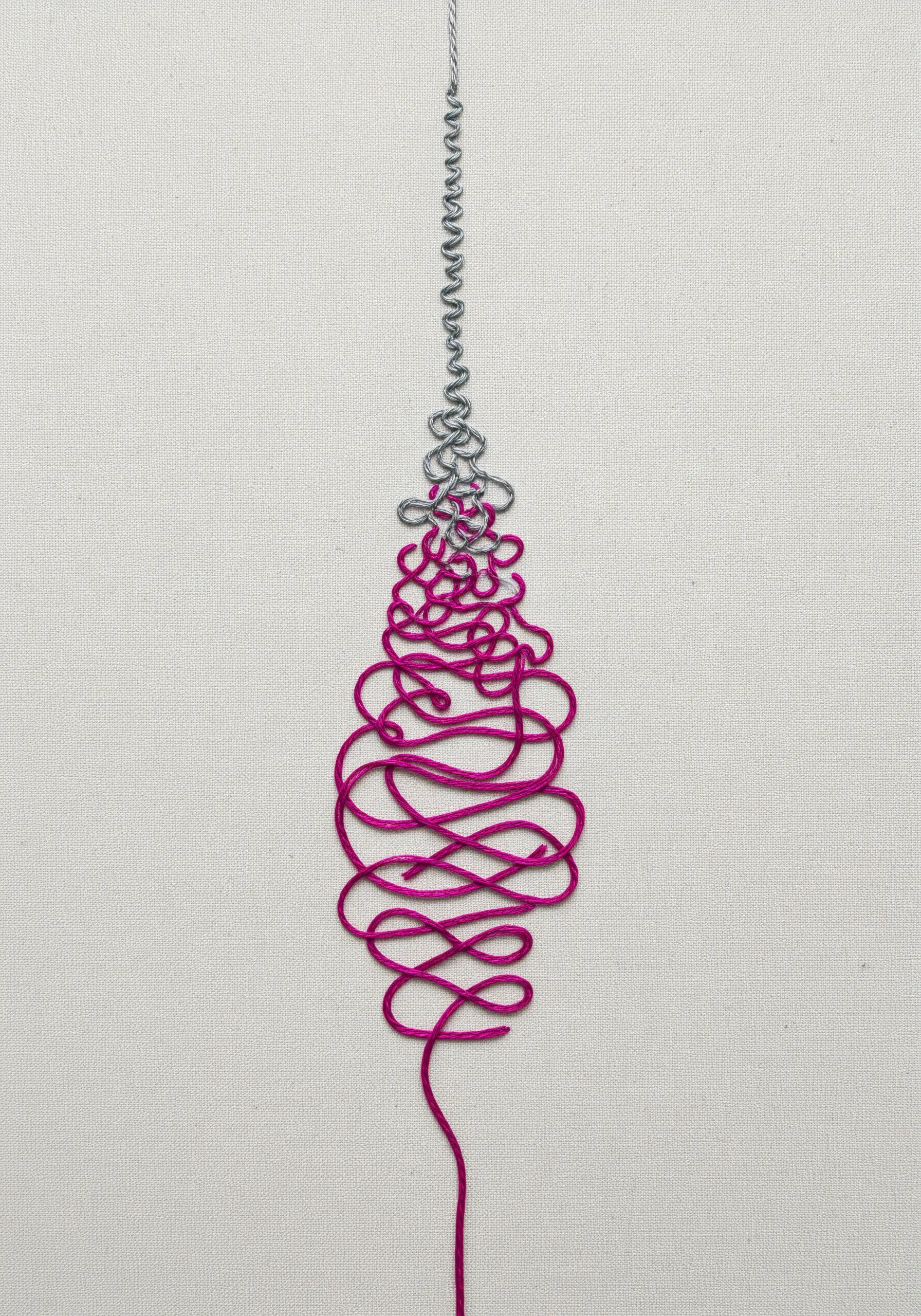 A thread transitioning from a tight grey coil to a chaotic magenta tangle.