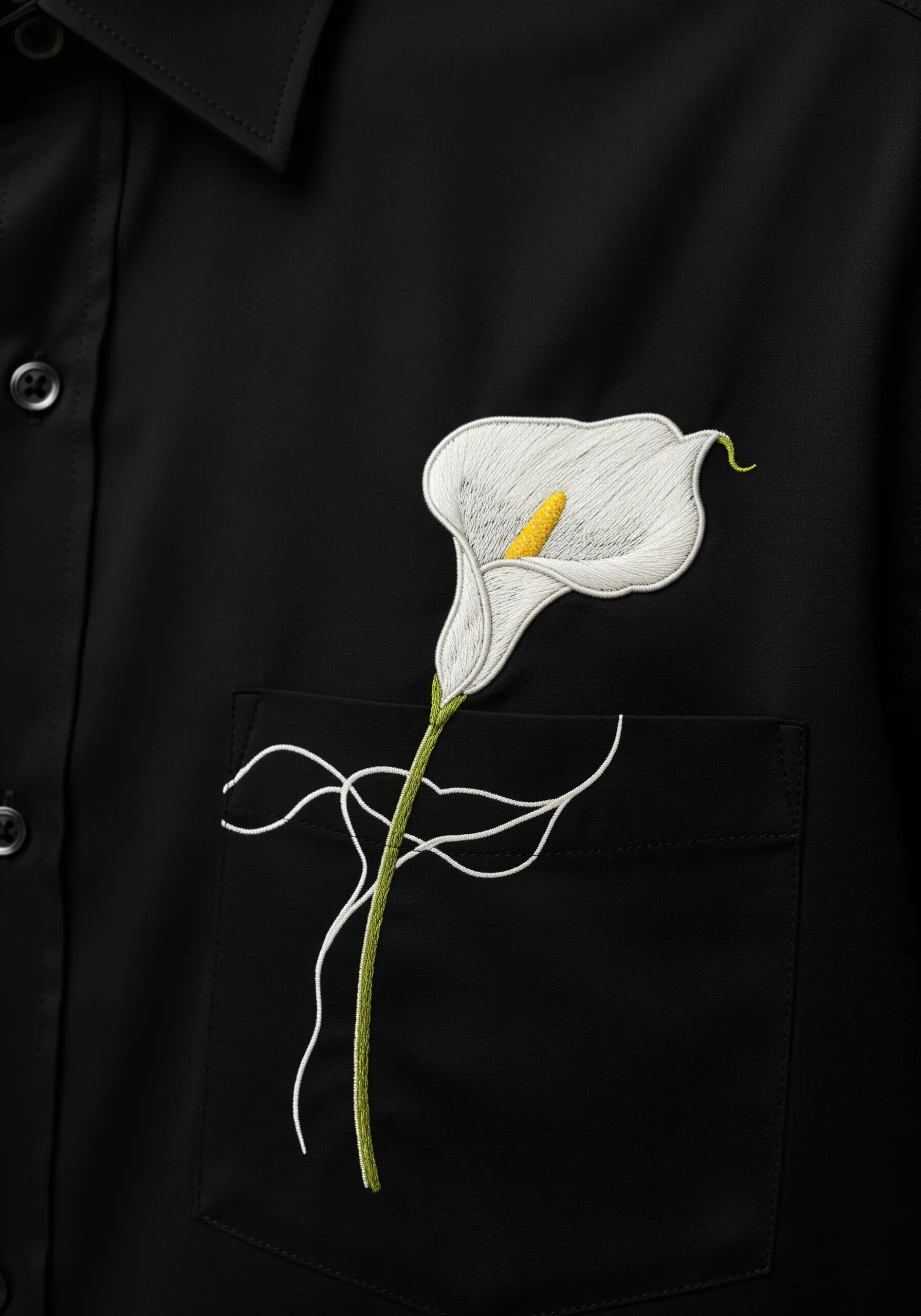 An elegant calla lily with long-and-short stitch shading embroidered on a black shirt.