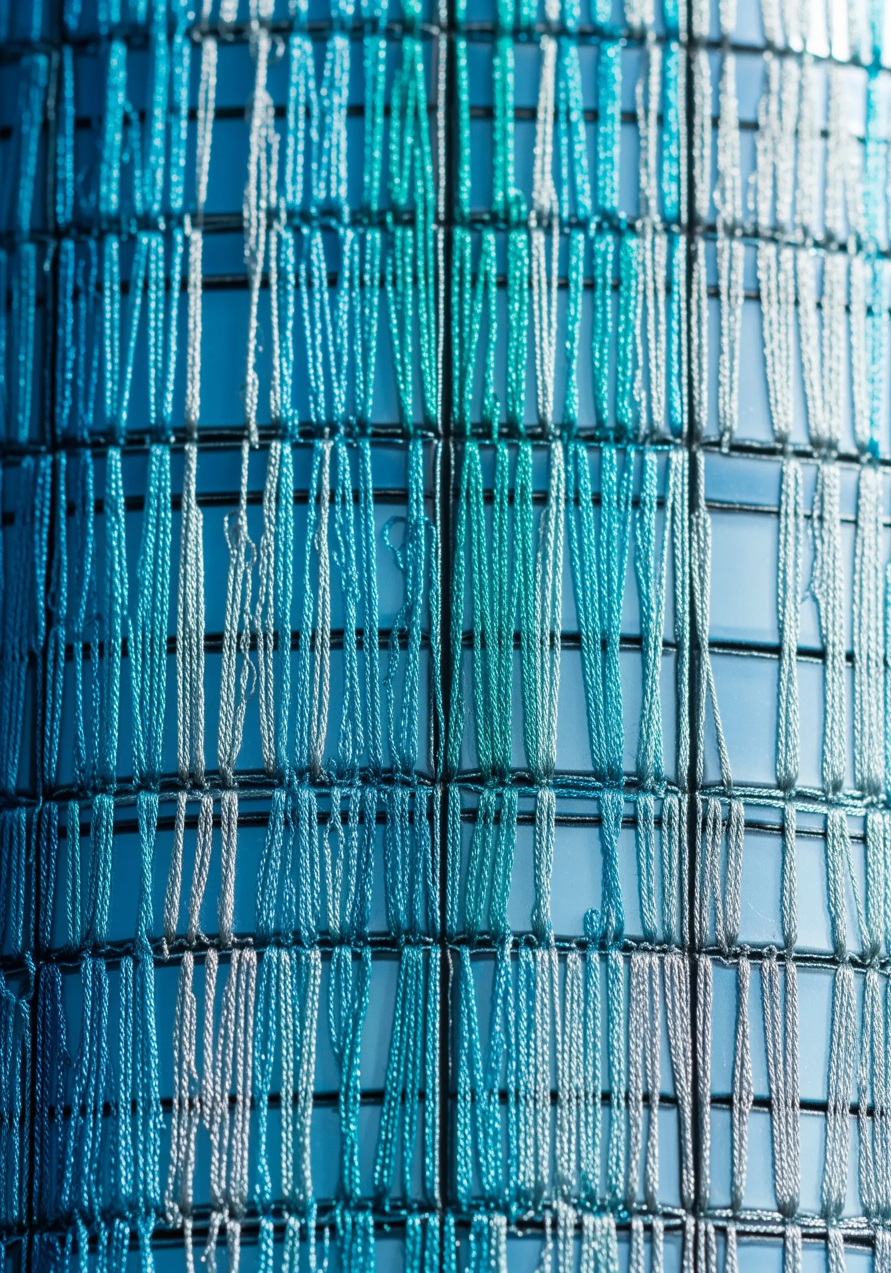 Abstract blue vertical stitches resembling a glass building facade
