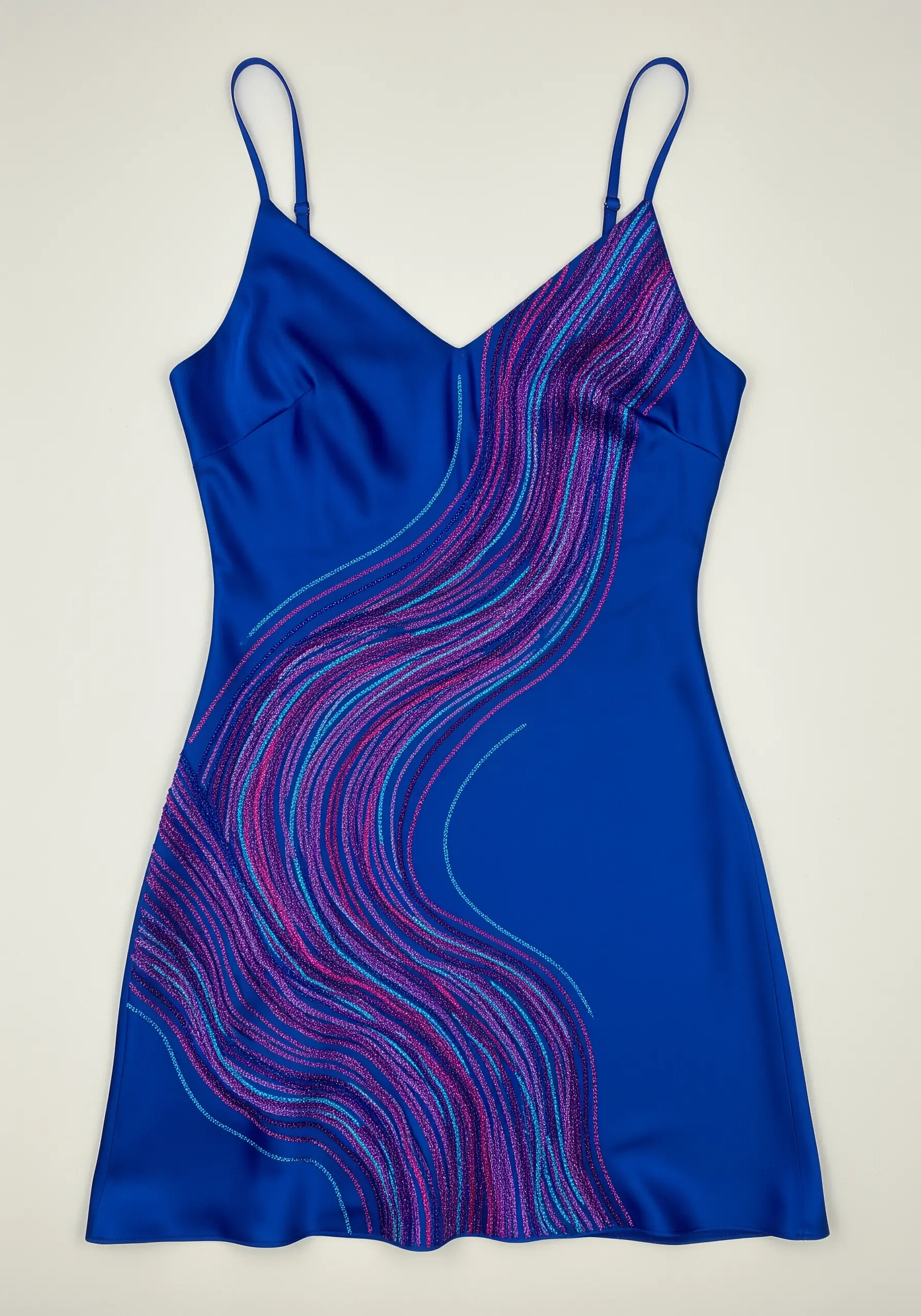 Abstract waves of pink, purple, and blue glitter thread on a royal blue satin slip dress.