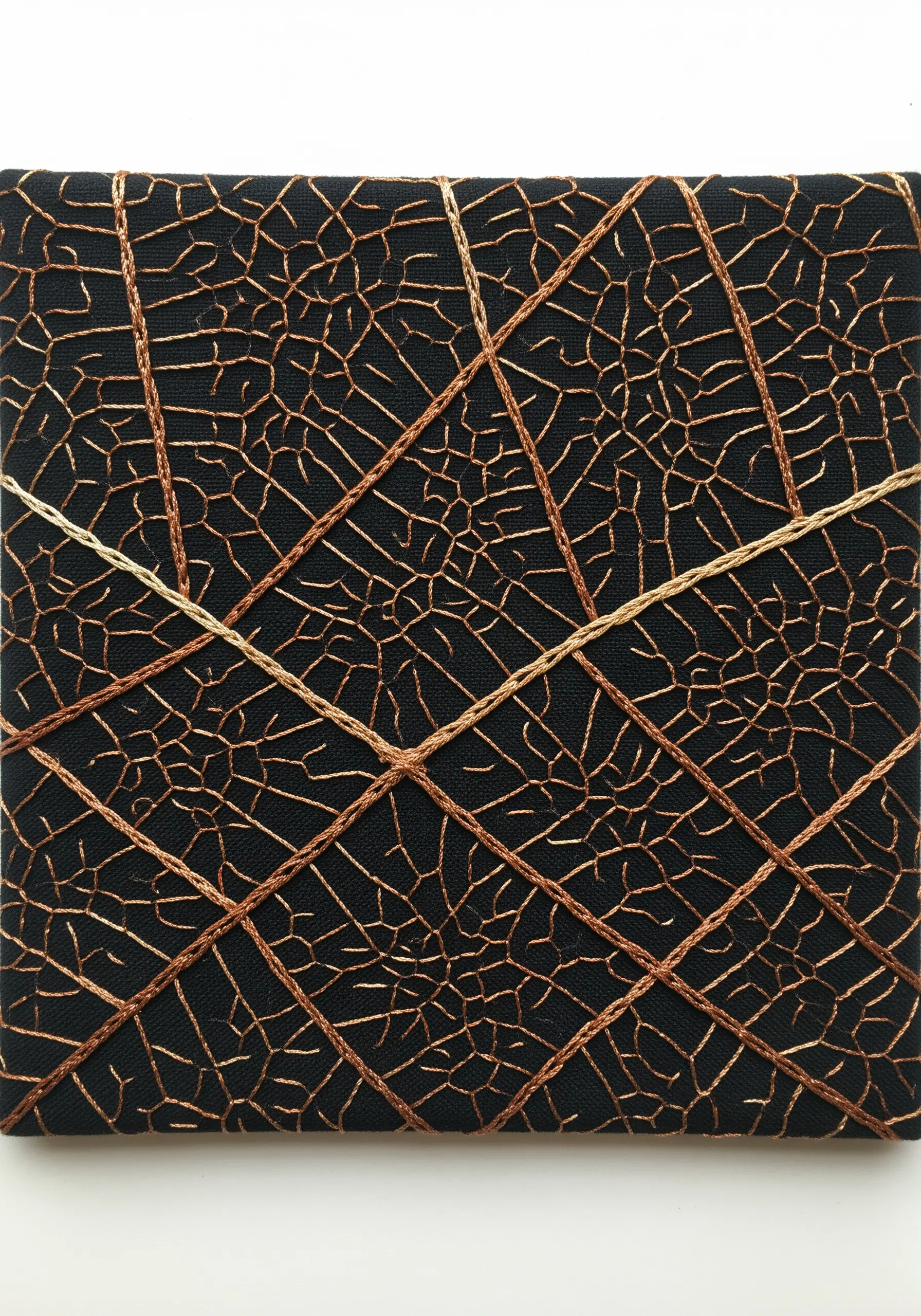 Abstract embroidery on black fabric with a dense network of copper thread veins and couched grid lines.