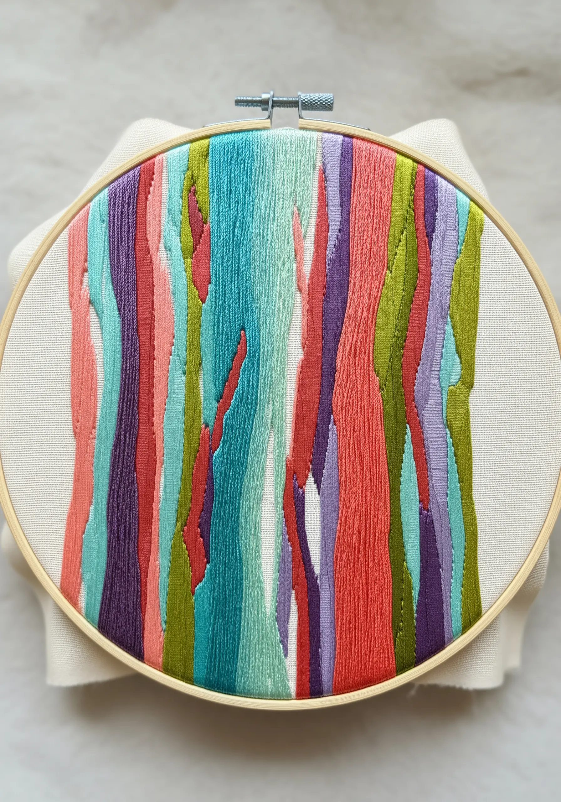 Abstract embroidery of colorful vertical bark shapes in teal, coral, purple, and green.