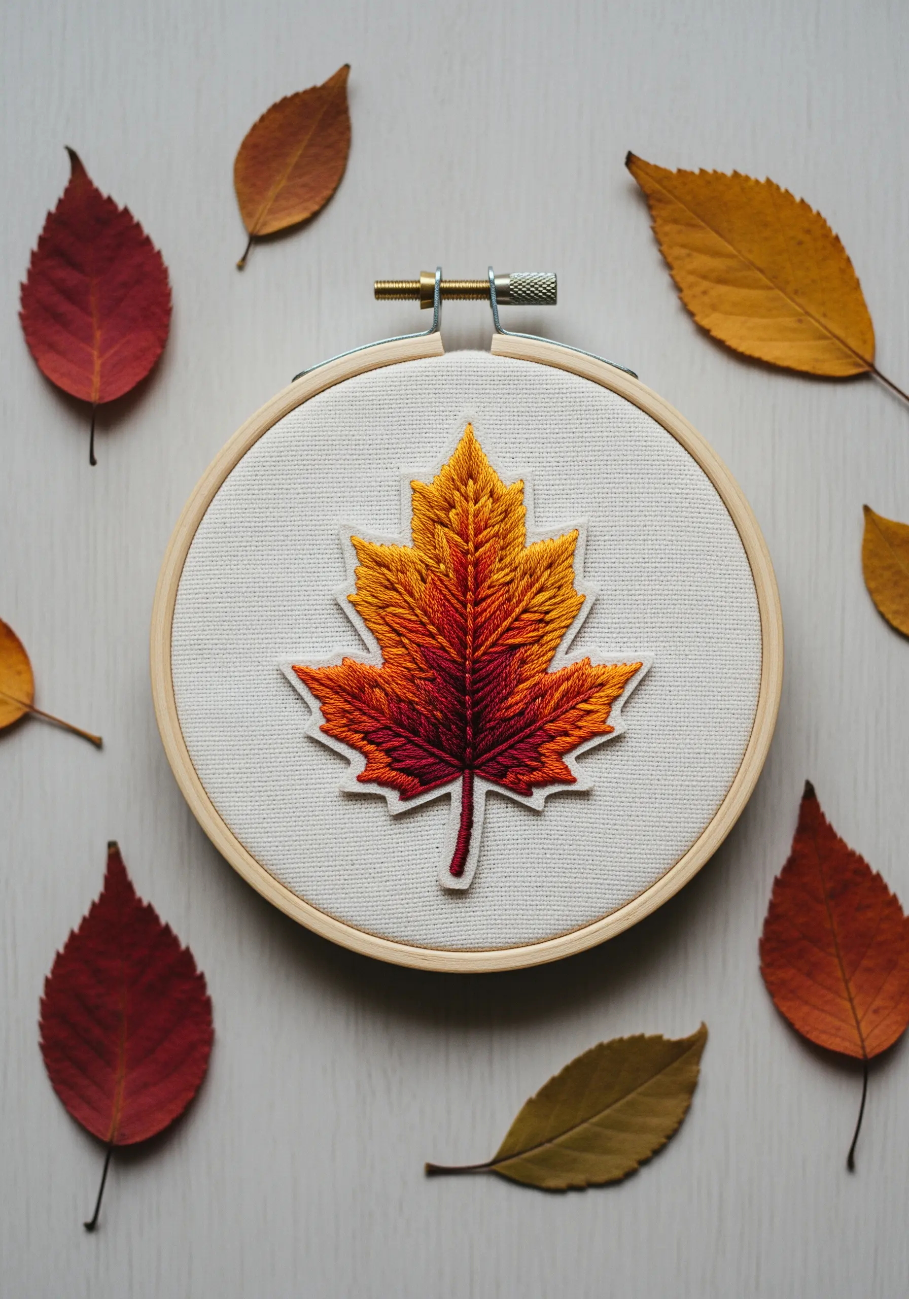 An autumn maple leaf patch with a red, orange, and yellow thread-painted gradient.