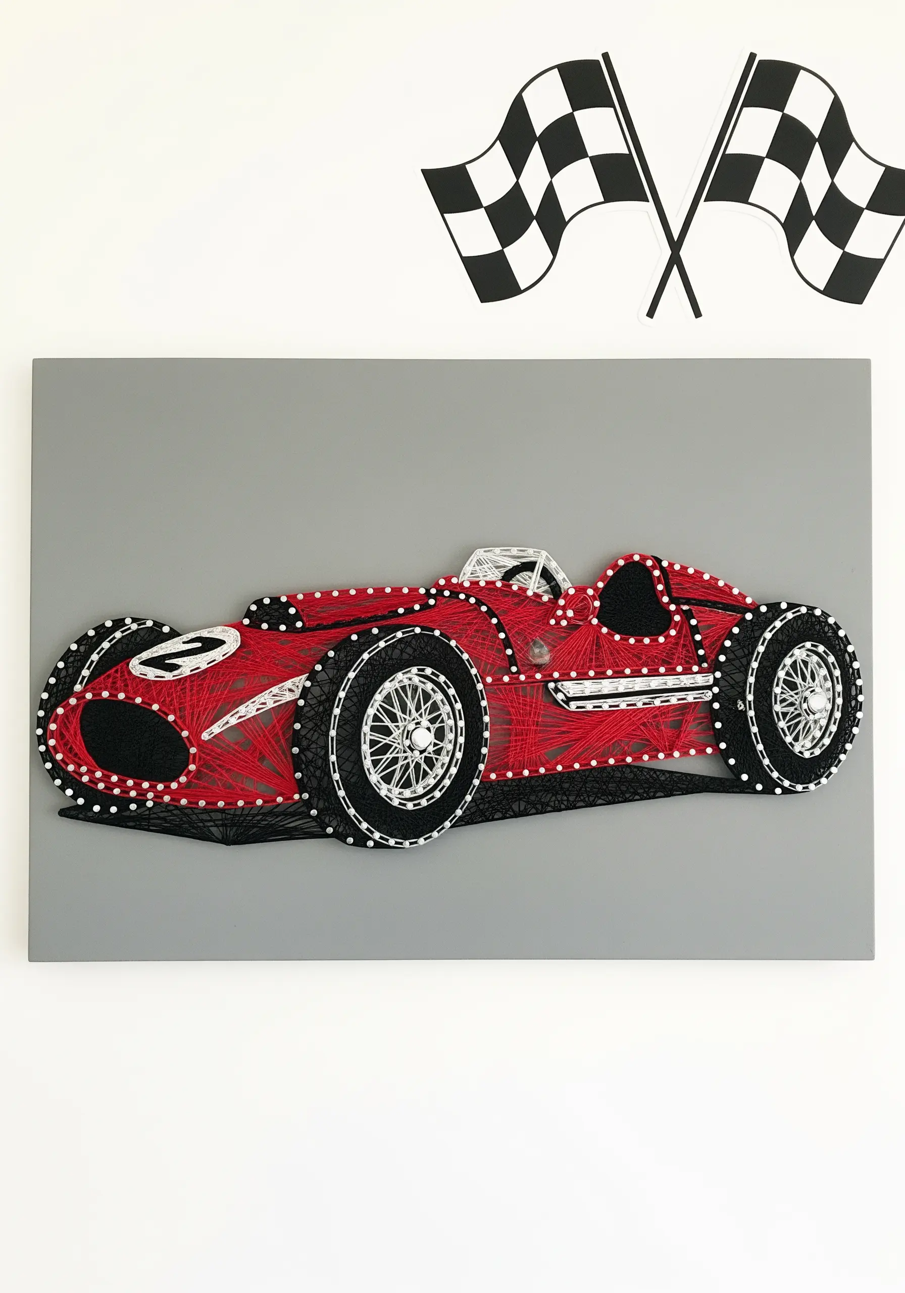 A vintage red race car embroidered with bold black outlines and a smooth satin stitch fill.