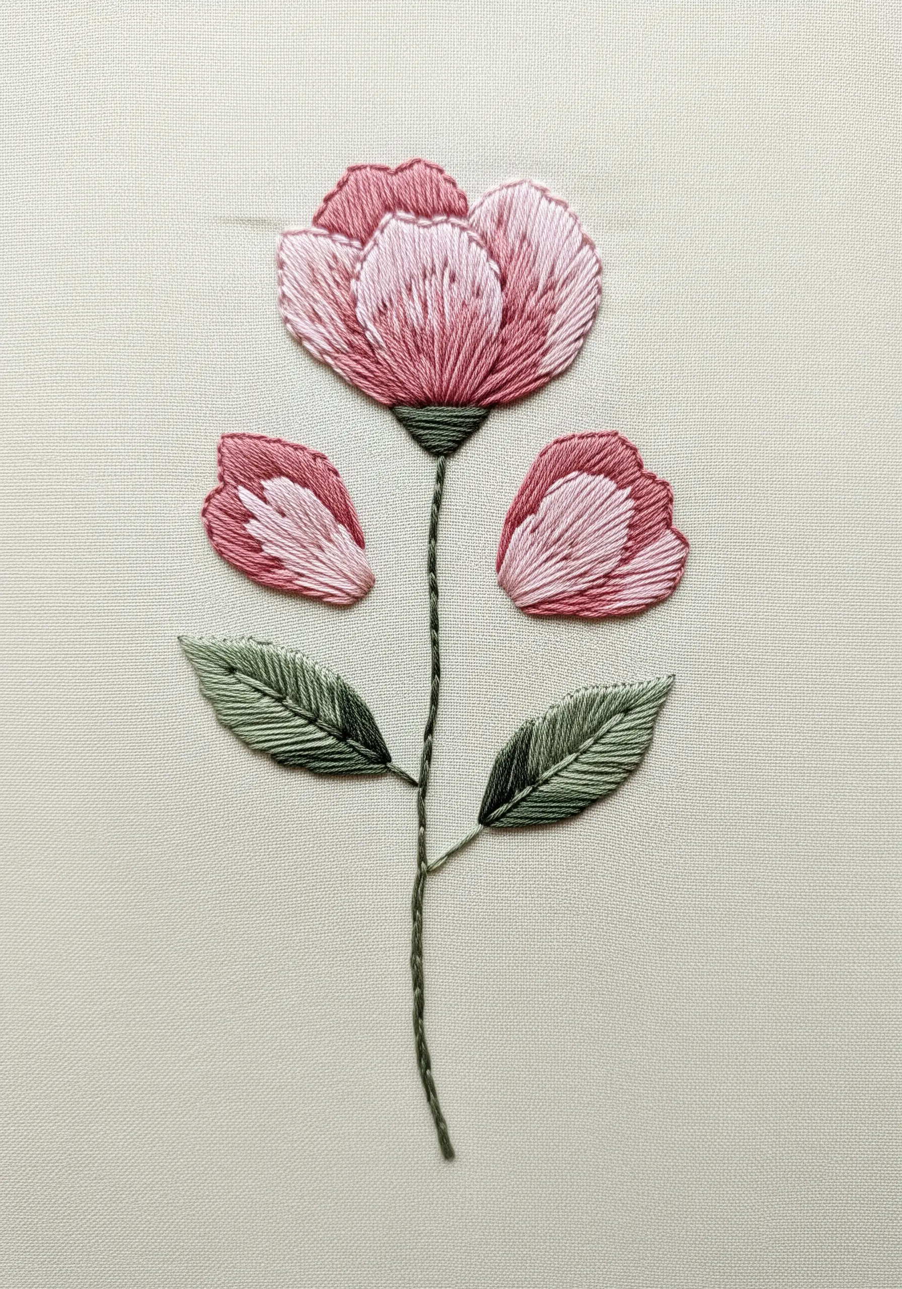 A pink flower embroidered with long-and-short stitch for a realistic, blended effect.