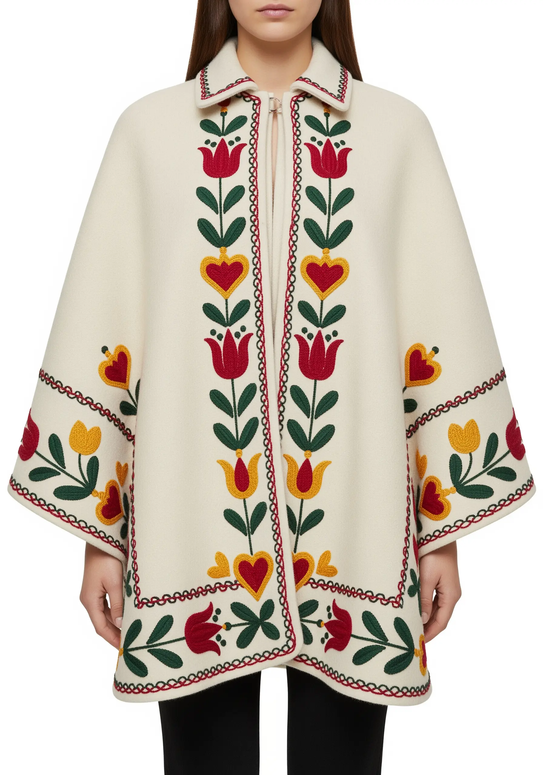 Symmetrical folk art floral embroidery in red, yellow, and green on a cream-colored wool cape.