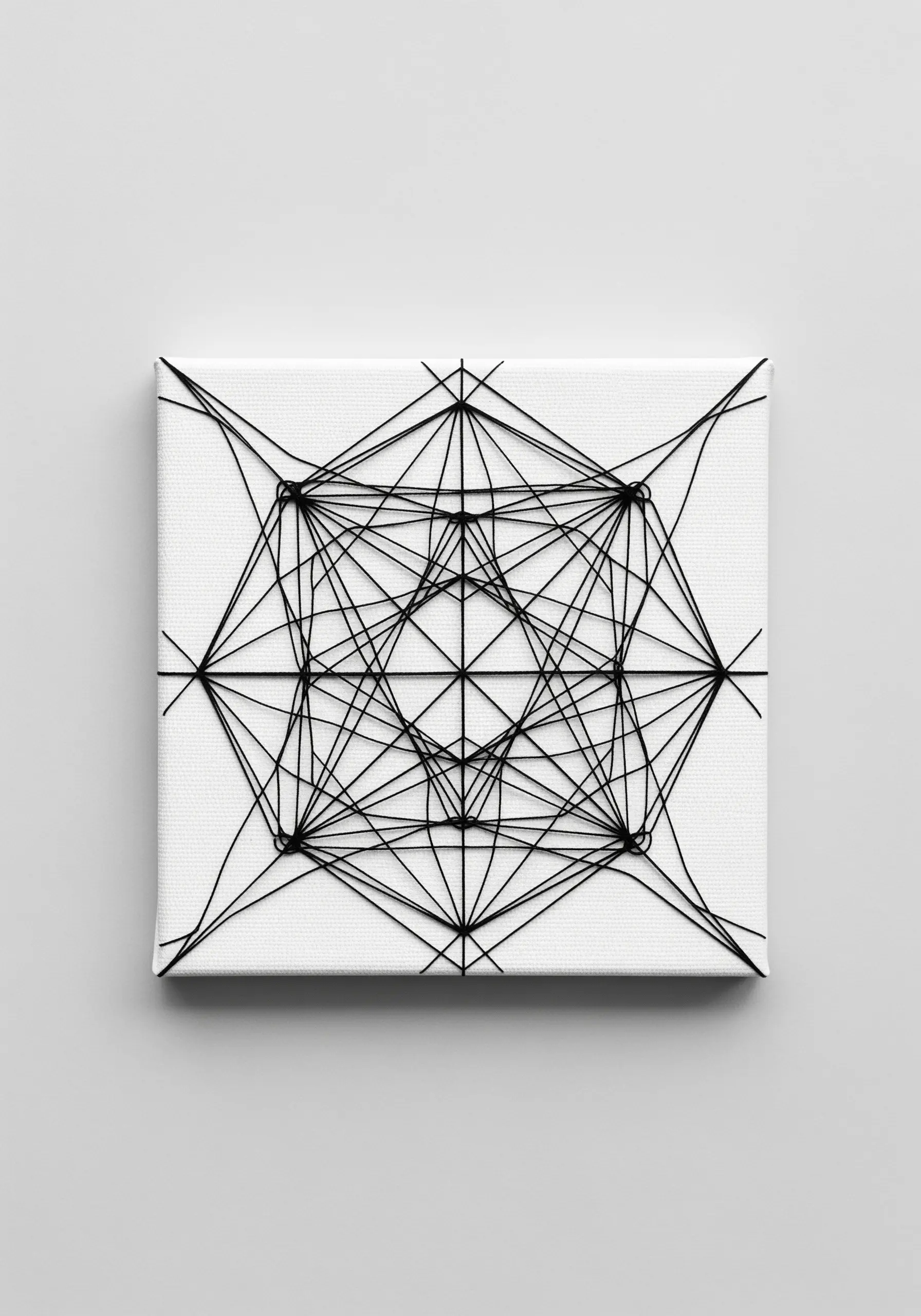 Geometric string art pattern with black thread on a white stretched canvas.