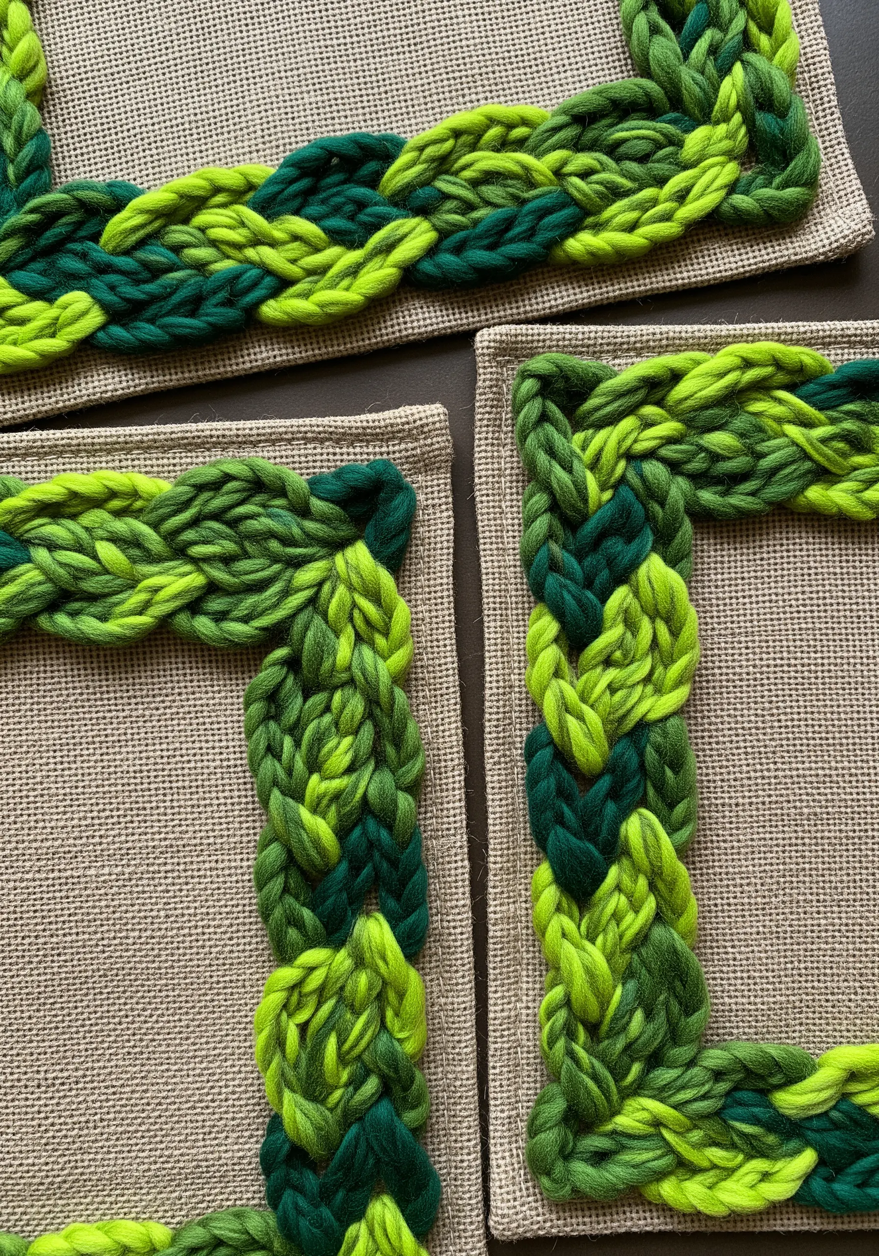 A chunky, braided border made of green yarn framing a burlap placemat.