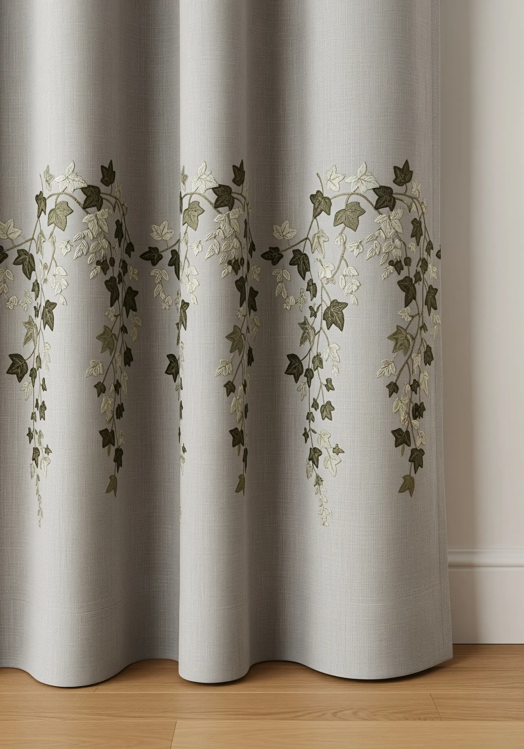 A gray linen curtain with a border of embroidered ivy in shades of dark green, sage, and cream.