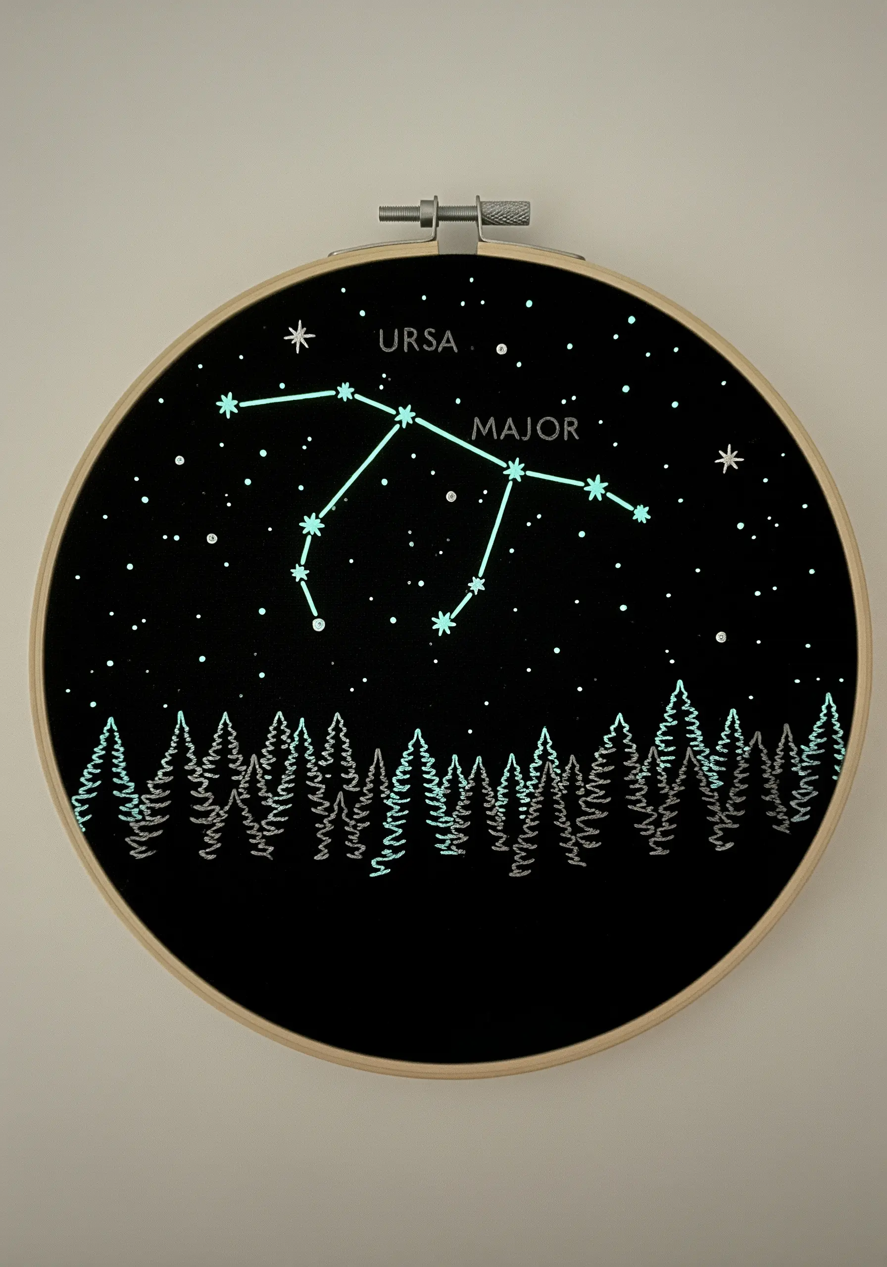 Glow-in-the-dark embroidered Ursa Major constellation above a forest silhouette.