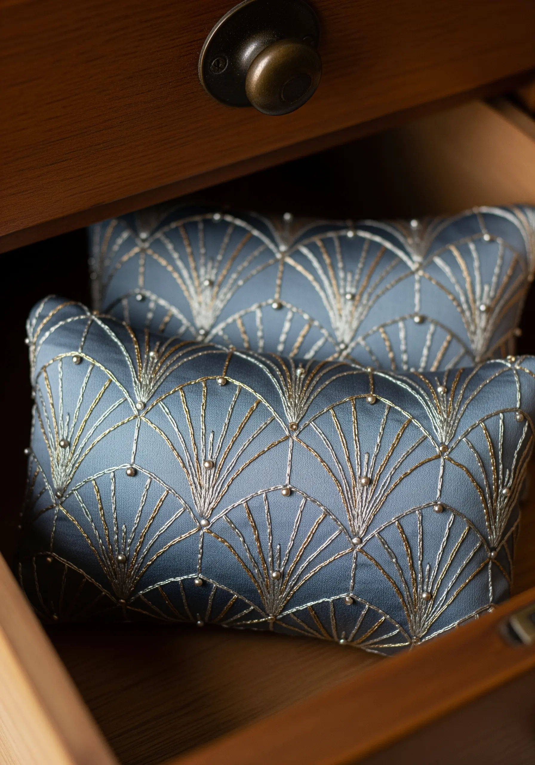Art Deco fan pattern embroidered on blue silk pillows with gold and silver metallic thread and beads.