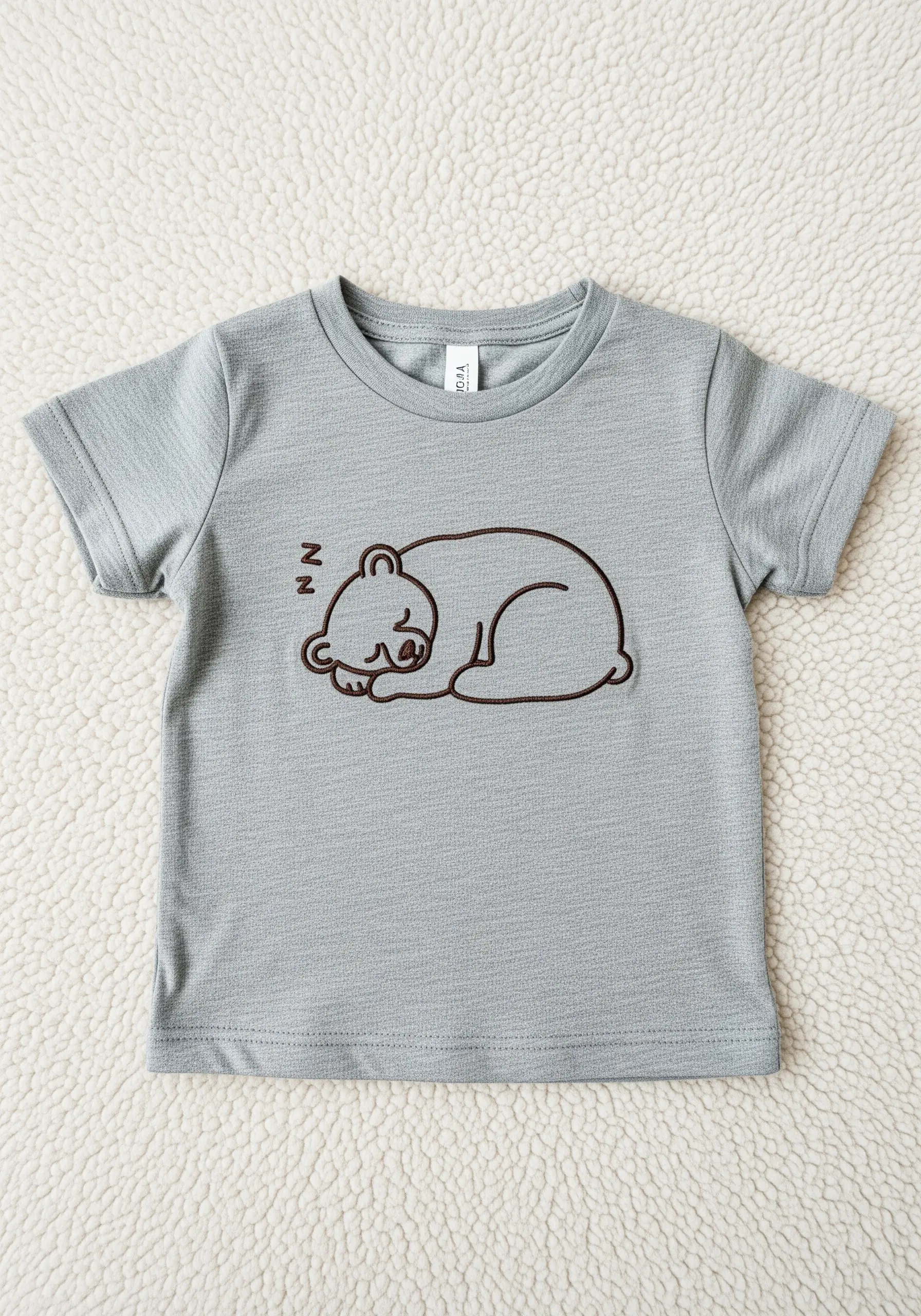 A sleeping bear outline stitched in brown thread with varied line thickness.