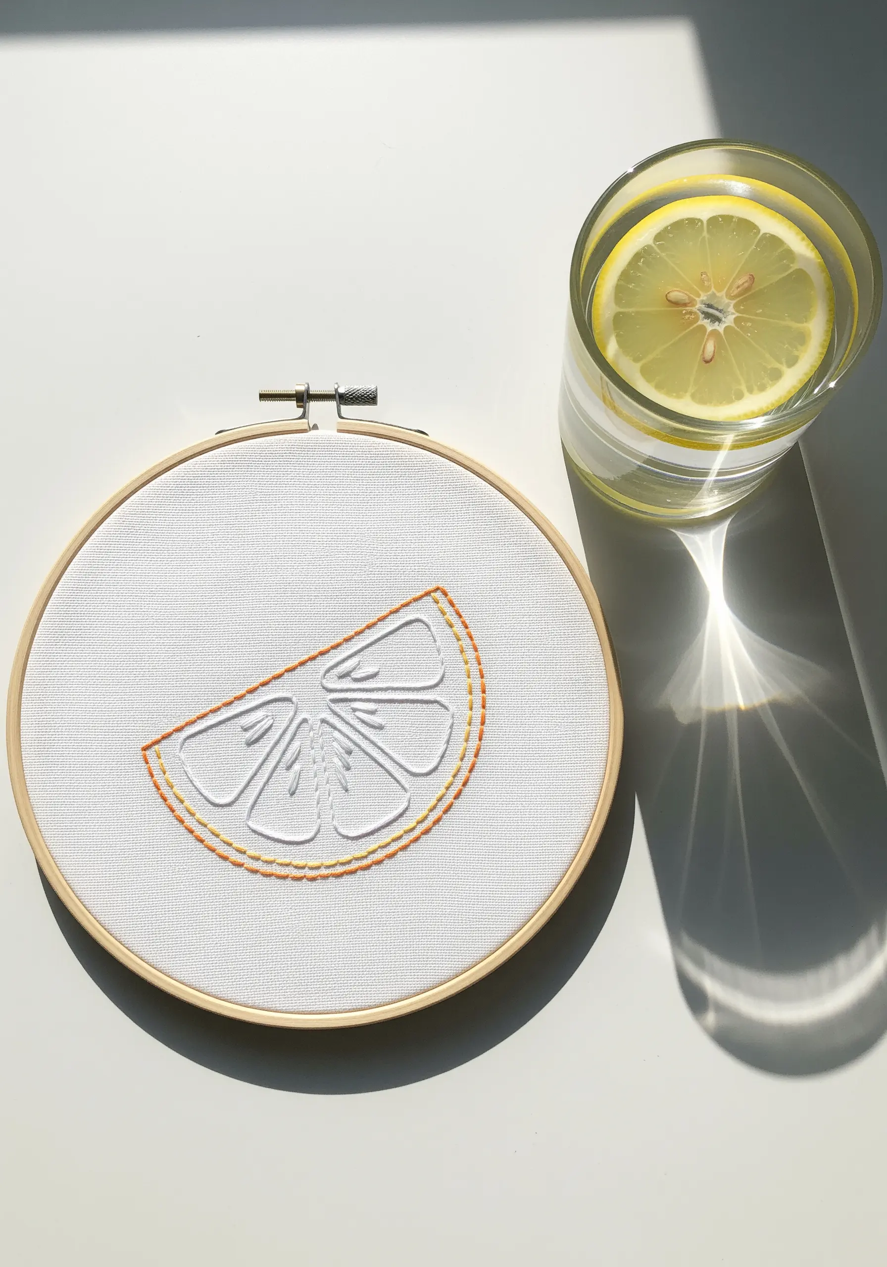 A minimalist outline of a lemon slice using two different line stitches.