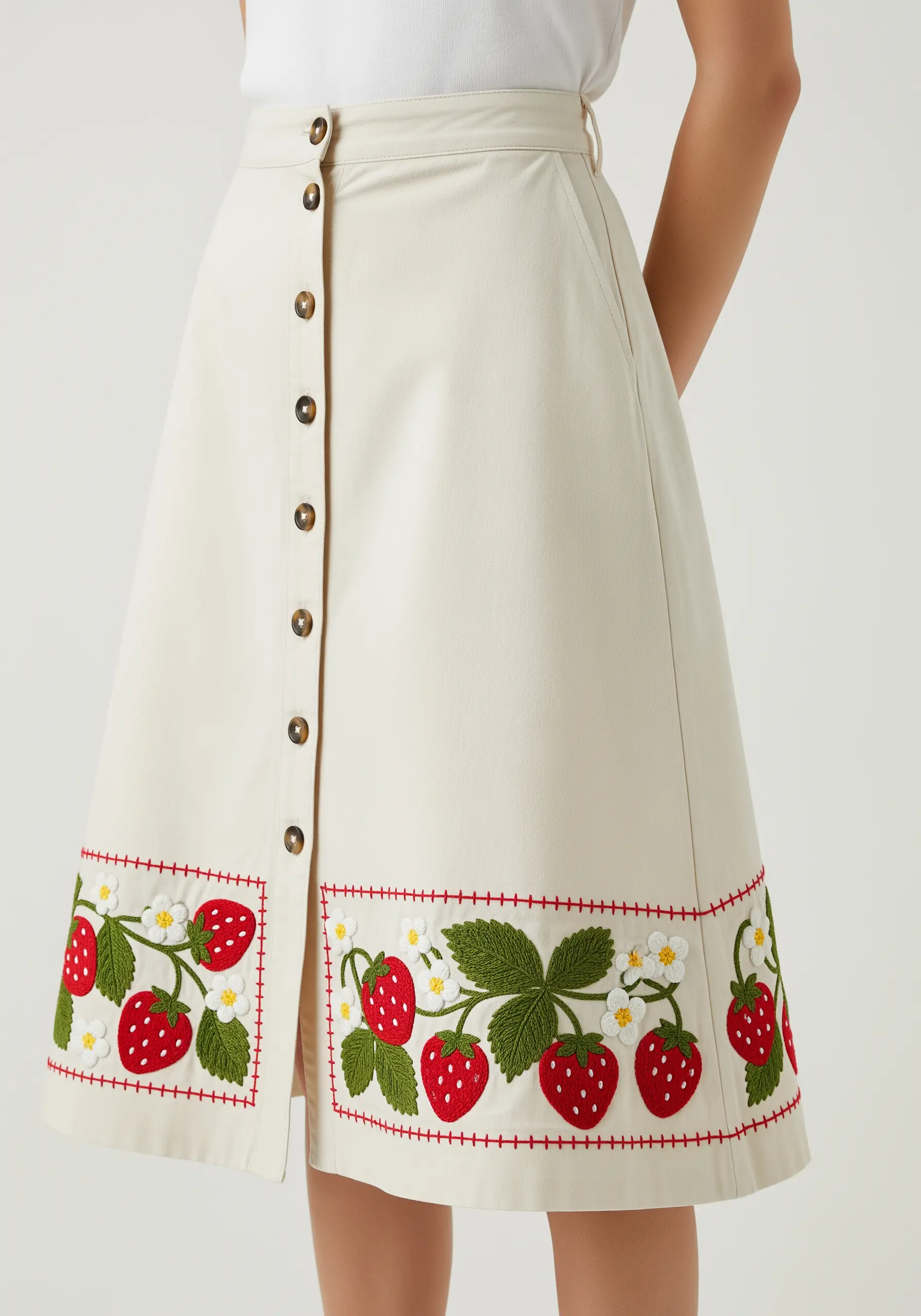 Embroidered strawberry border on a button-front A-line skirt.