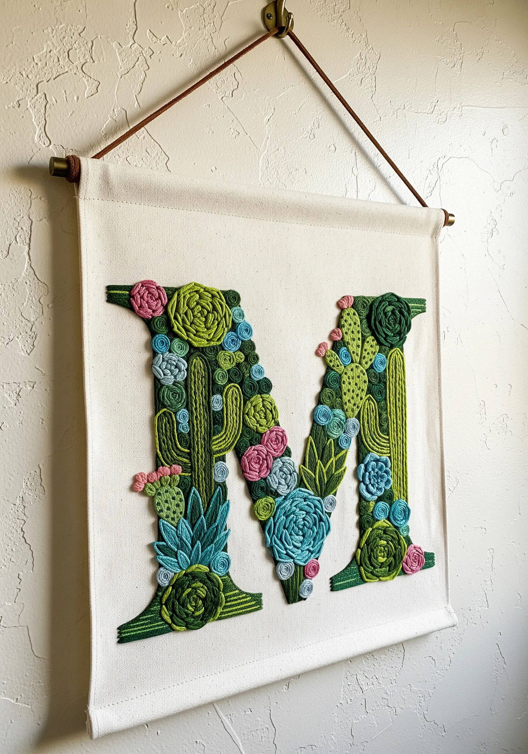 Canvas banner with letter M completely filled with embroidered succulents and cacti