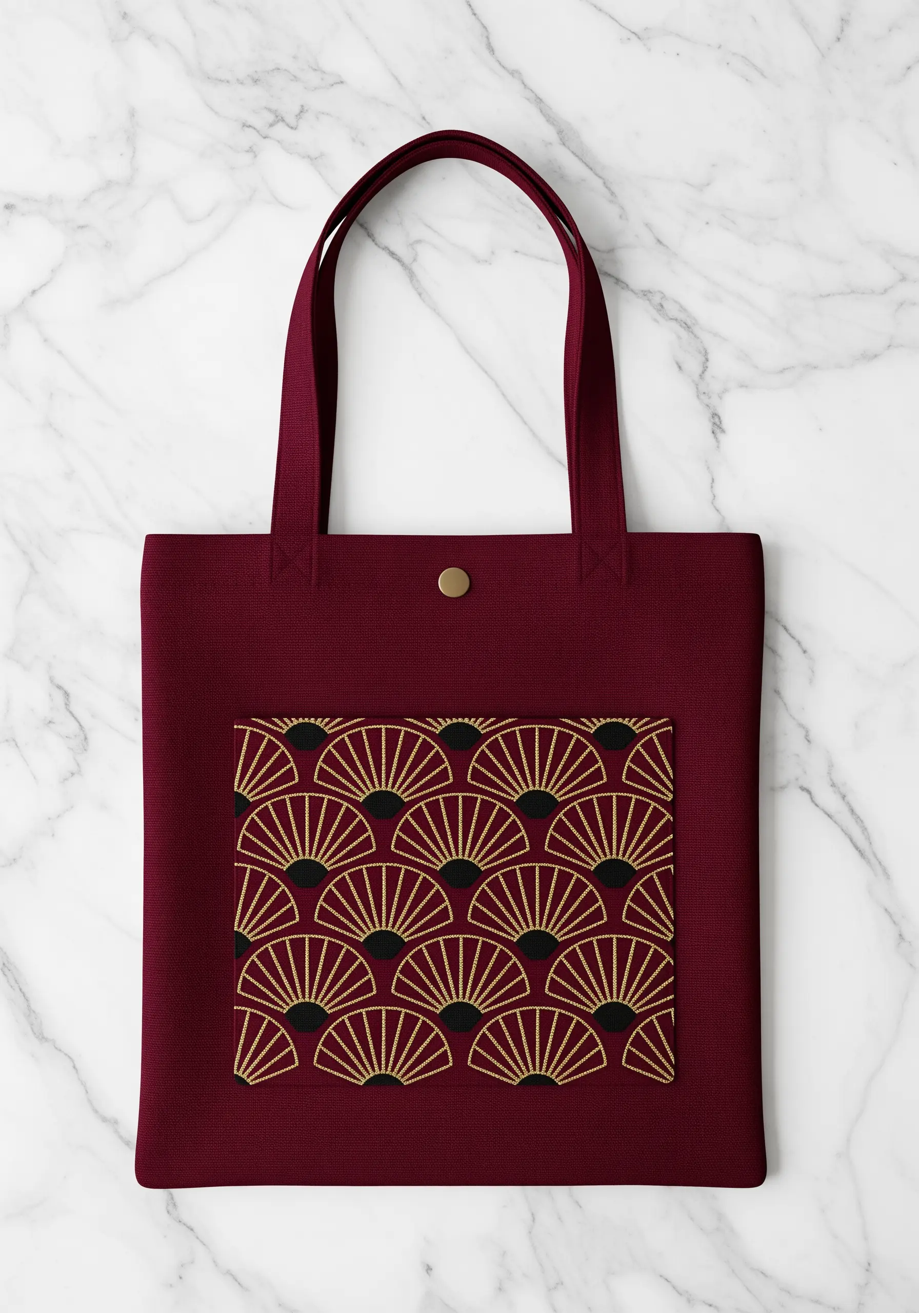 An Art Deco pattern of gold and black fans embroidered on a burgundy tote bag pocket.