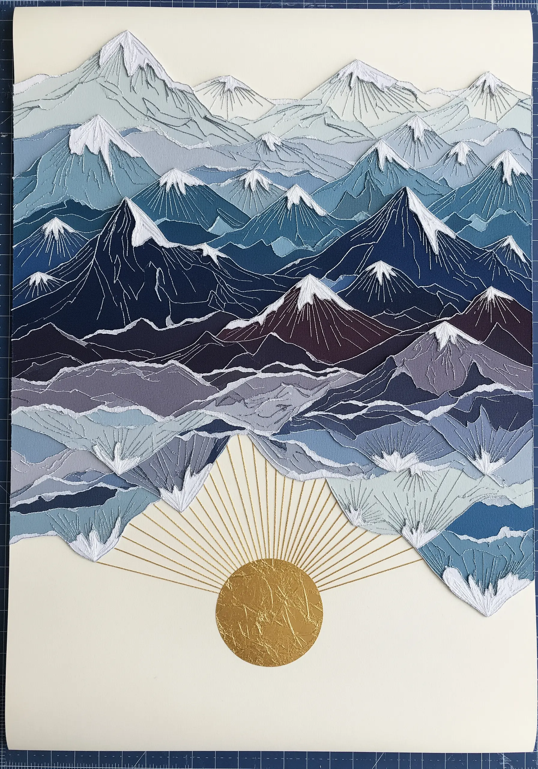 A layered mountain range embroidery using translucent fabrics to create a sense of depth.