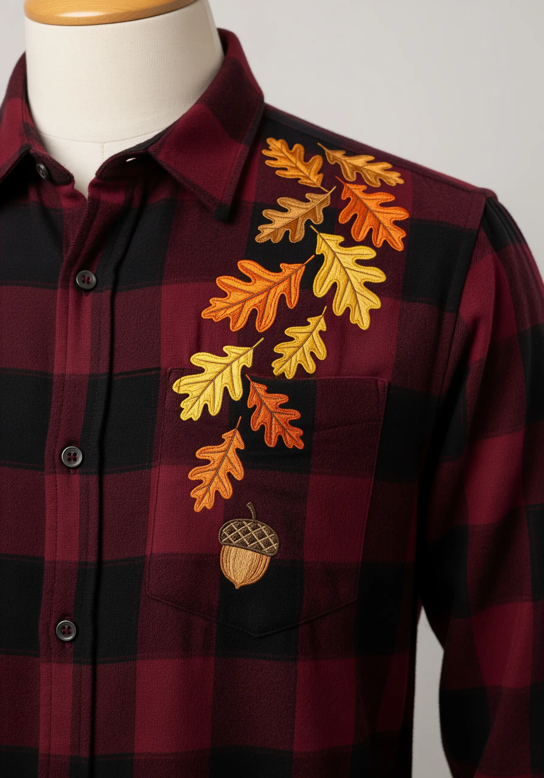 A cascade of autumn-colored oak leaves embroidered on a red and black flannel shirt.
