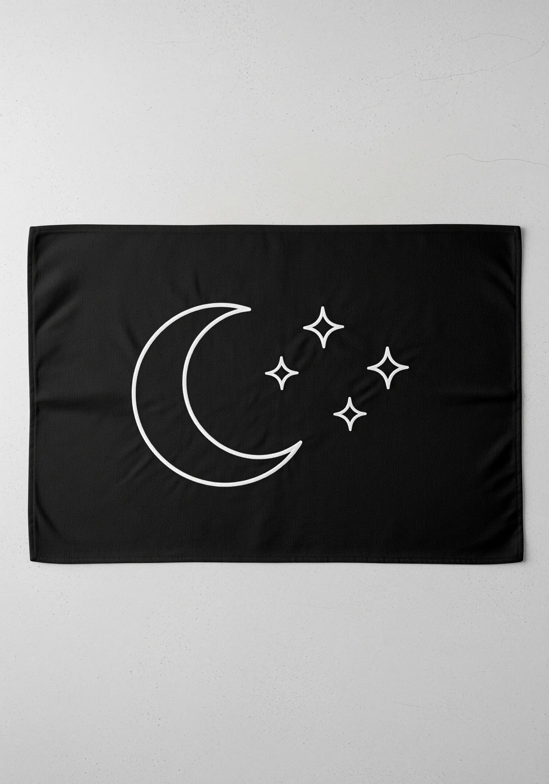 A bold white crescent moon and four-point stars embroidered on a black fabric background.