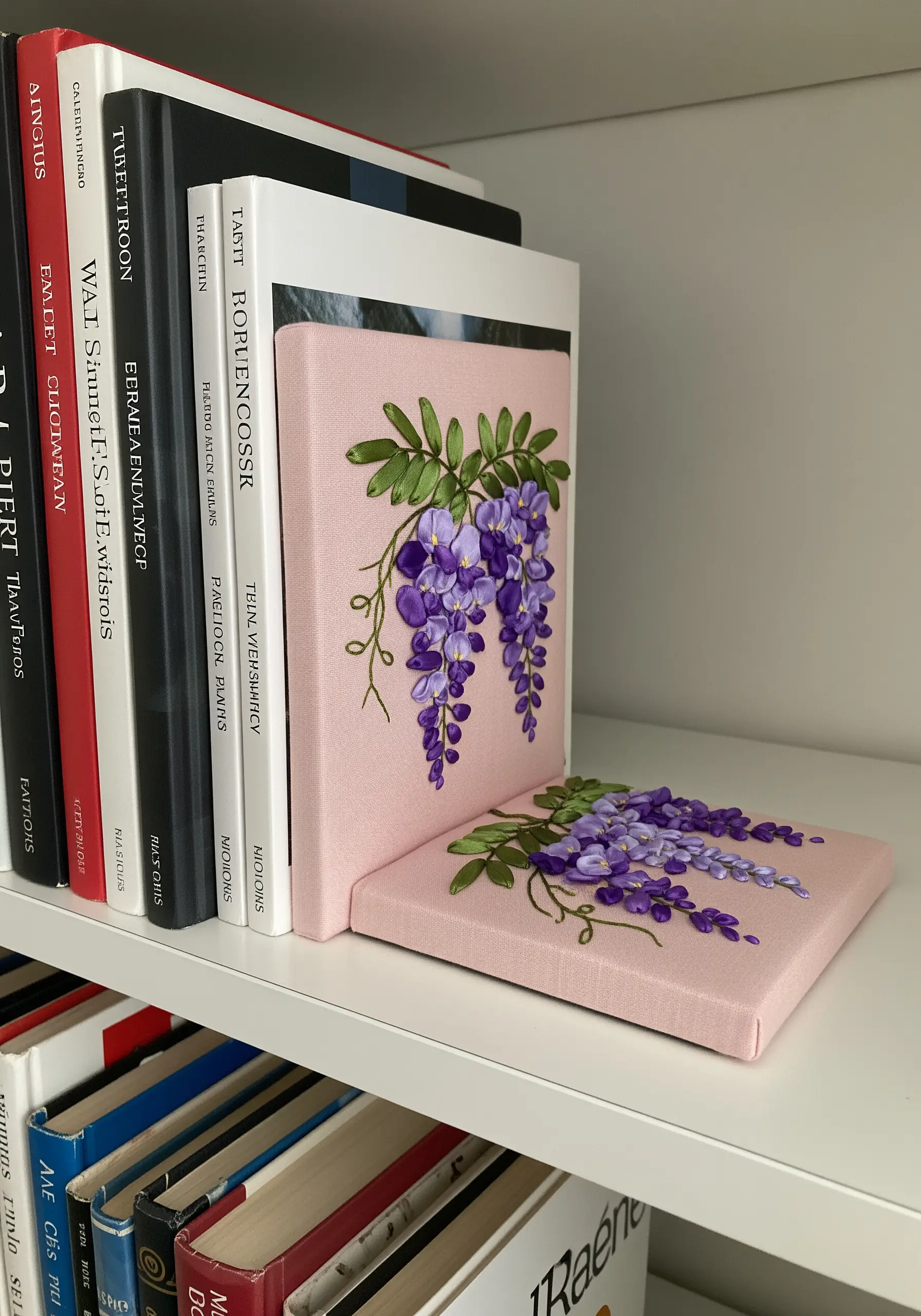 Pink fabric-covered bookends with purple wisteria made from silk ribbon embroidery.
