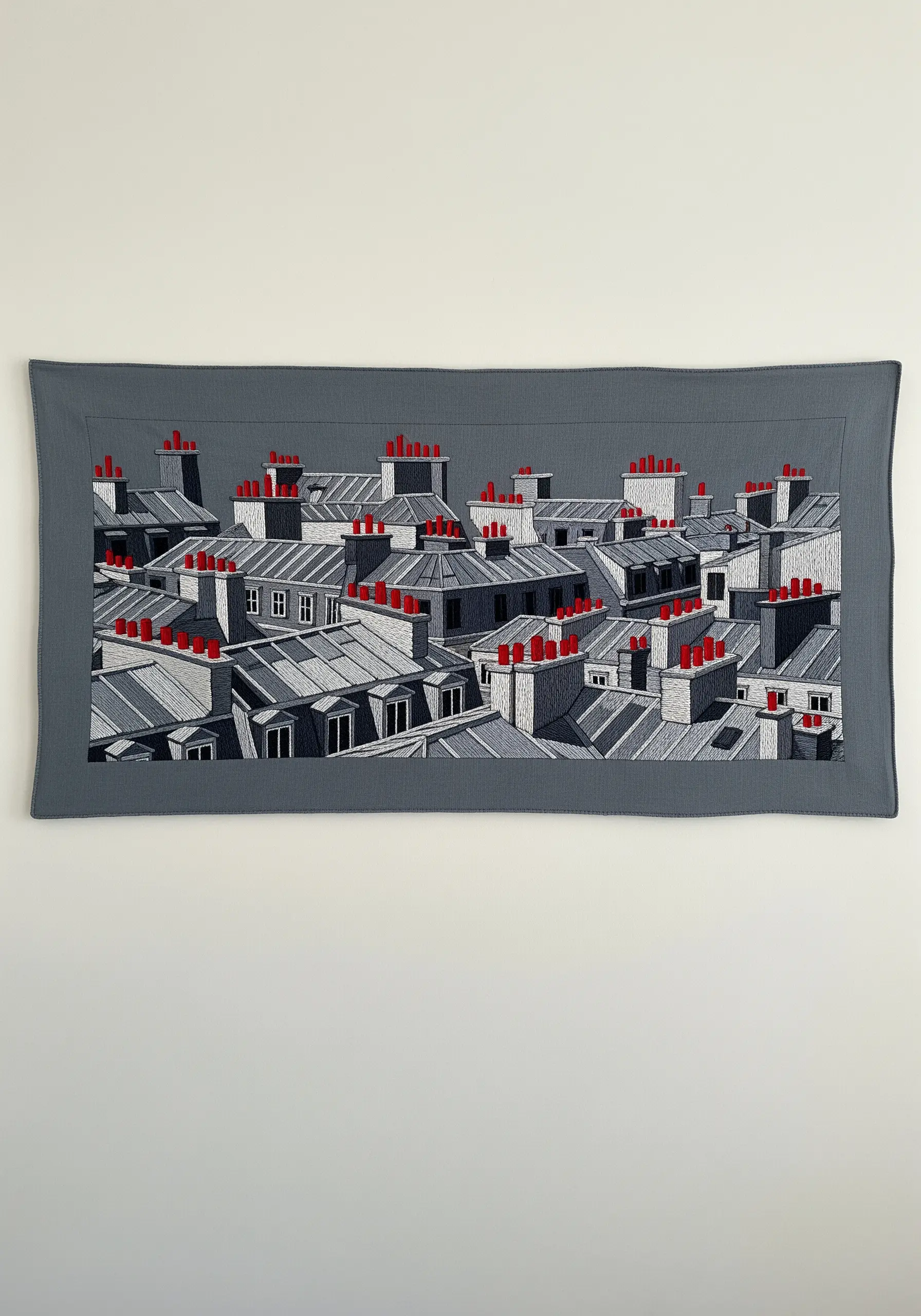 An embroidered Parisian rooftop scene in grayscale with bold red chimney accents.