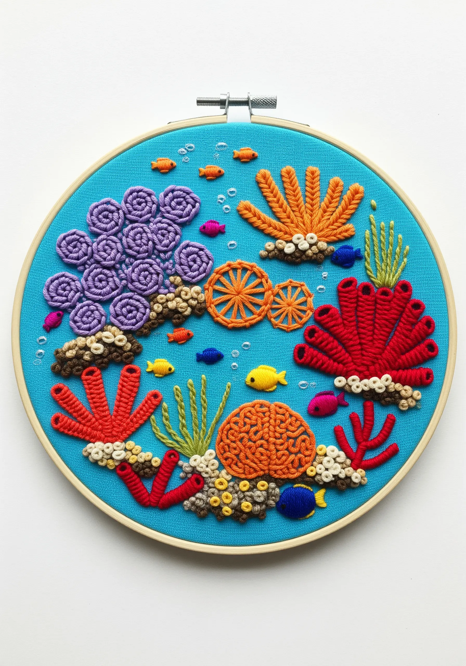 A vibrant and textural embroidered coral reef with bullion knots and woven wheel stitches.
