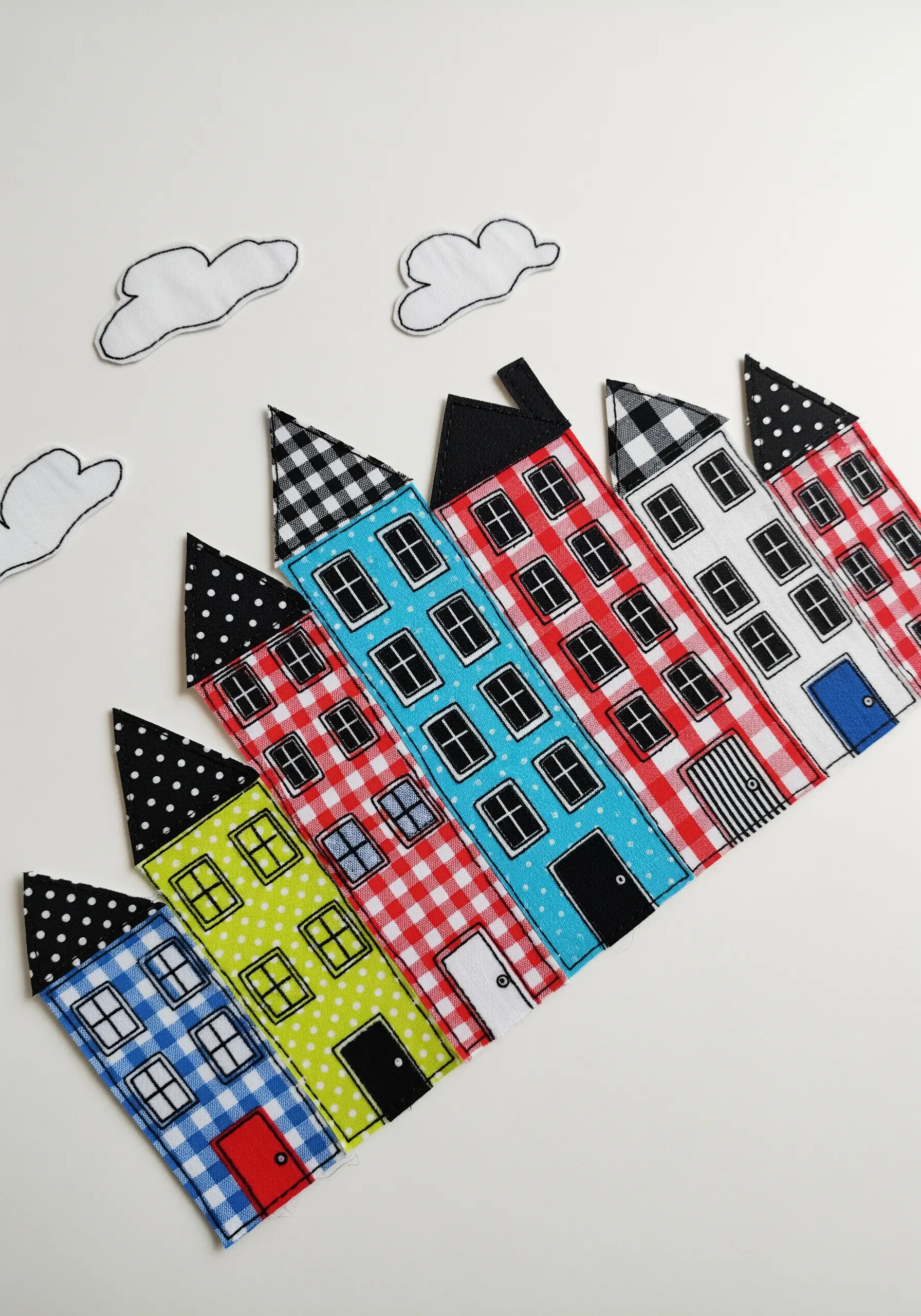 A colorful row of appliqué houses made from various patterned fabrics.