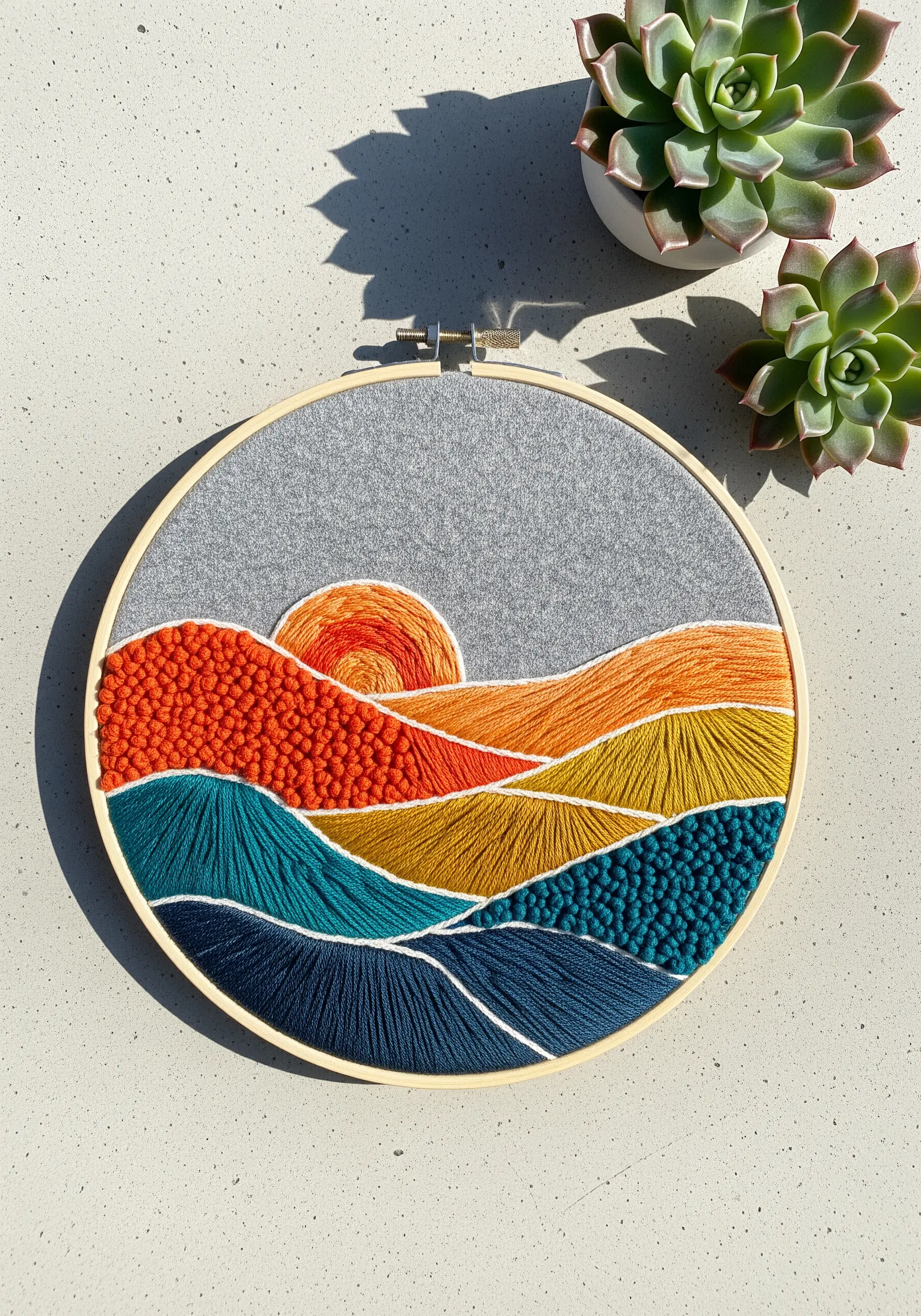 Abstract hoop art of rolling hills in sunset colors, using various textural fill stitches.